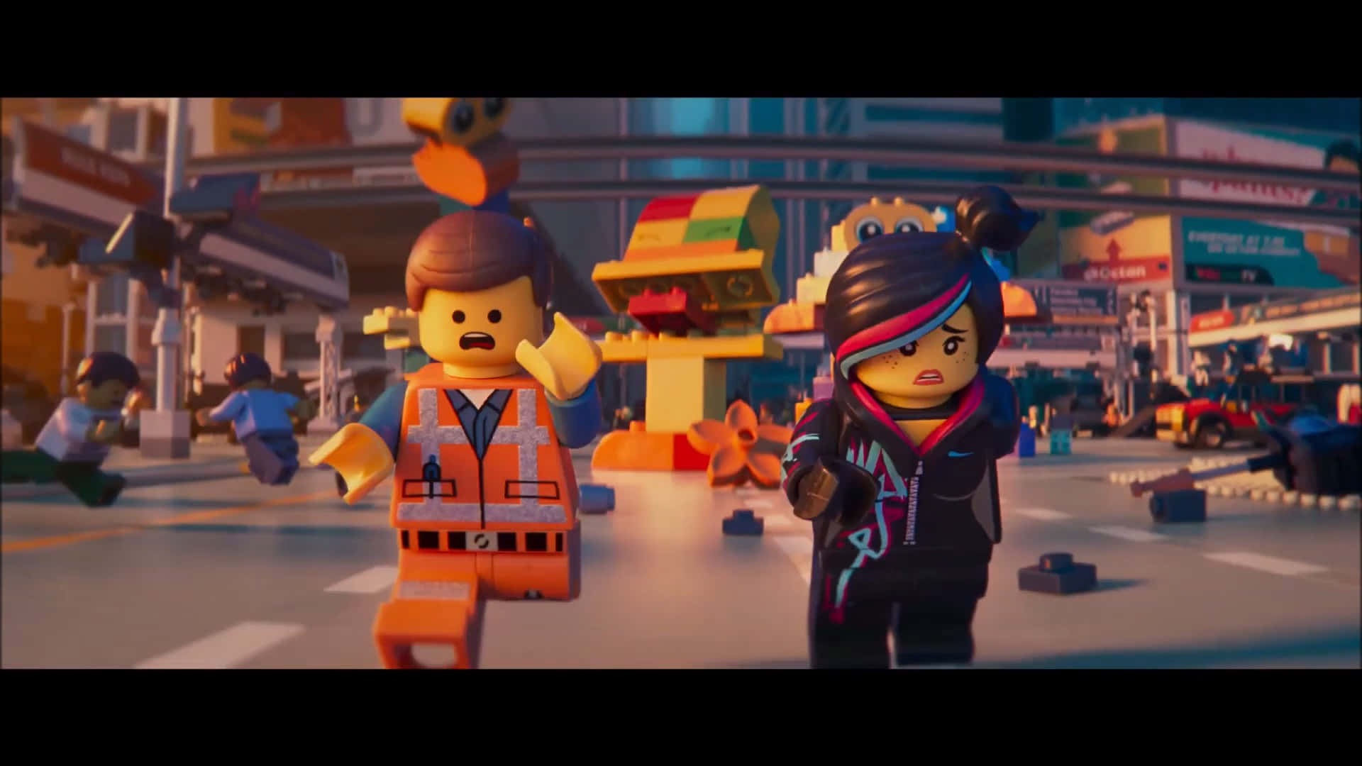 樂高 桌布 壁紙 — 兩個 LEGO 角色在溫暖的金色光芒下，跑過一條充滿色彩繽紛建築物和散落磚塊的繁華城市街道。
