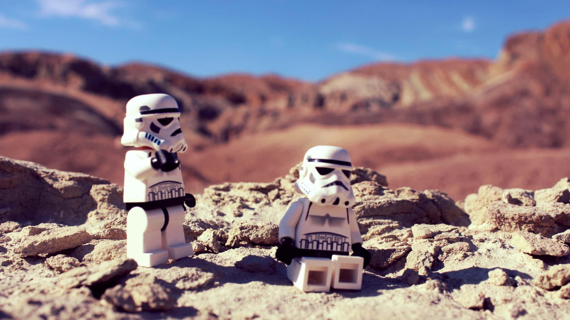 Tatooine 桌布 壁紙 — 兩個 LEGO 風暴兵站在陽光普照的沙漠峽谷中，紅色岩石地貌，藍天白雲。
