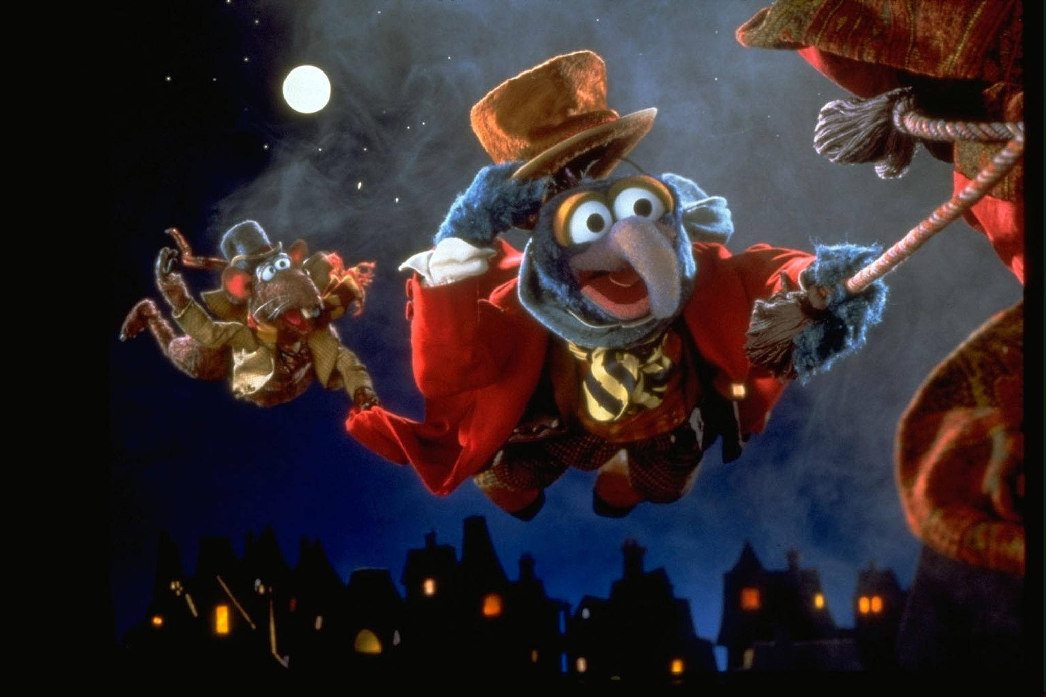 A 桌布 壁紙 — 兩個 Muppet 角色在星空下翱翔，越過一個窗戶發光的剪影小鎮。