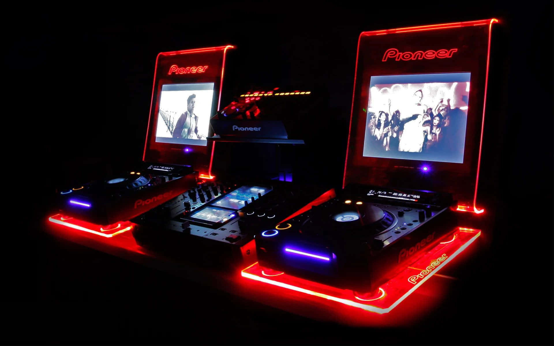 Neon Lights Aesthetic 桌布 壁紙 — 兩個 Pioneer DJ 唱盤在黑色背景上發出紅藍光芒，螢幕上顯示人群和表演者的視覺效果。