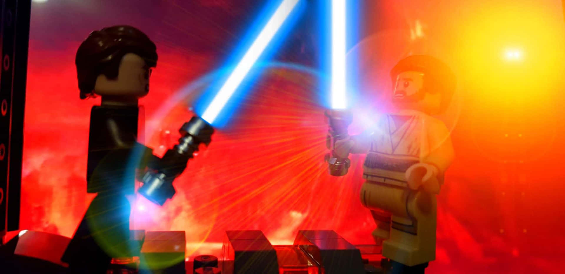 The Battle Of The Heroes 桌布 壁紙 — 兩個LEGO 星際大戰人偶在熾熱的紅色和橙色背景下，用發光的藍色光劍決鬥。