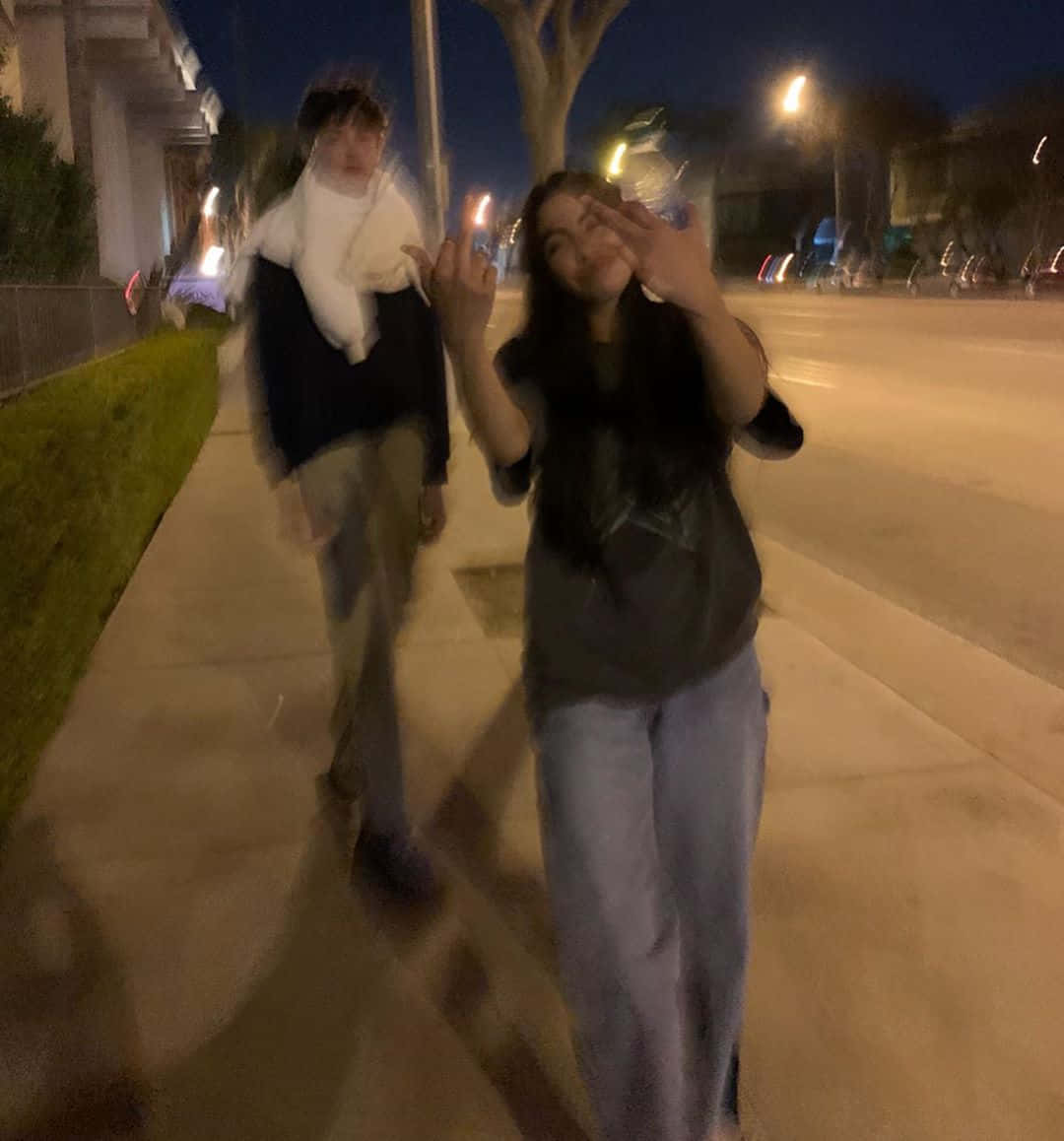 情侶 桌布 壁紙 — 兩個人在夜間於人行道上行走，帶有動態模糊效果，街燈散發溫暖的光芒。