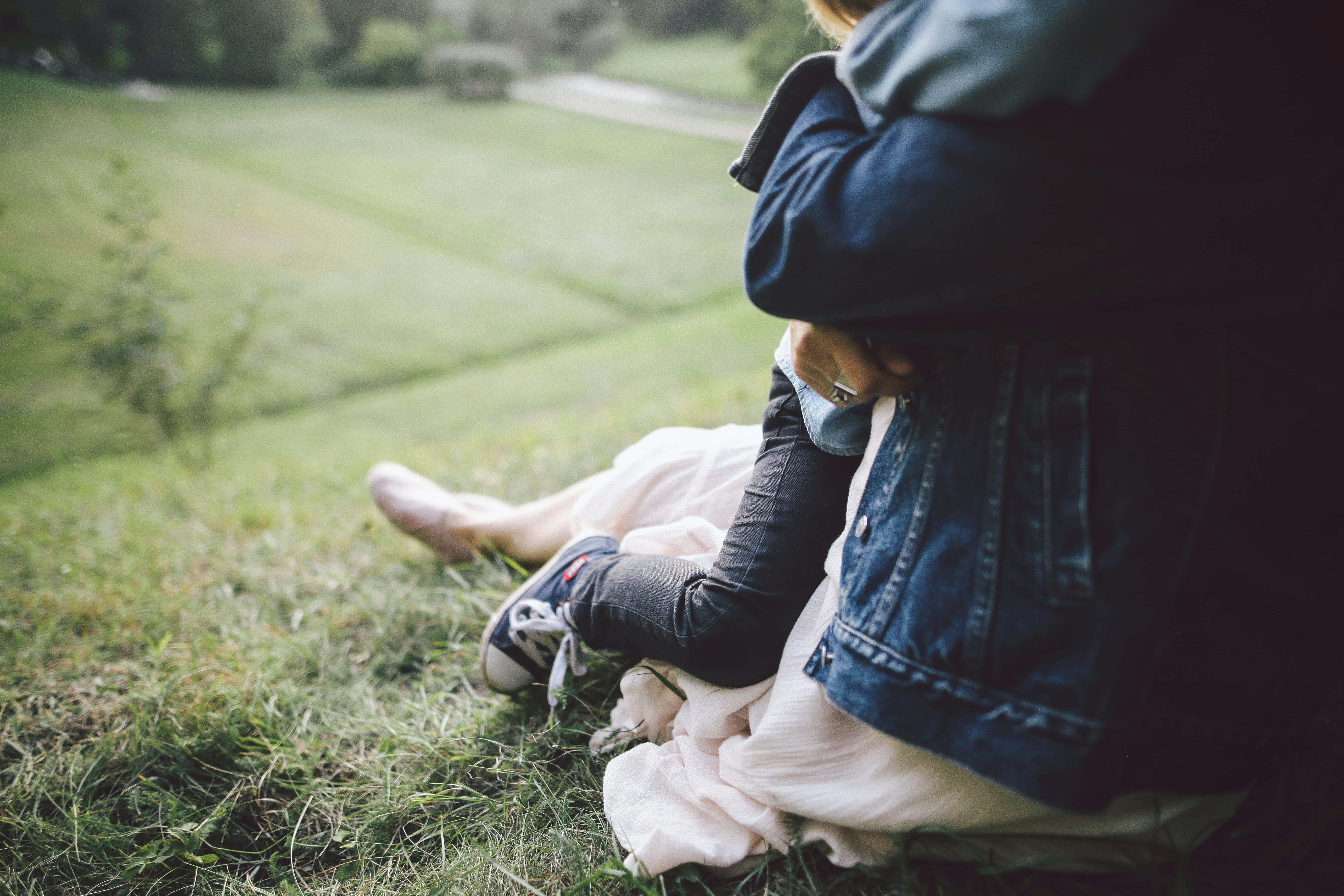 Mom 桌布 壁紙 — 兩個人在寧靜的戶外草地上坐得很近，柔和自然光。