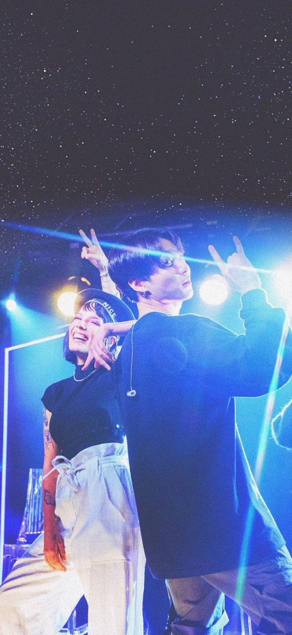 Halsey 桌布 壁紙 — 兩個人在明亮的藍色舞台燈光下擺出搖滾手勢，背景是星空夜空。