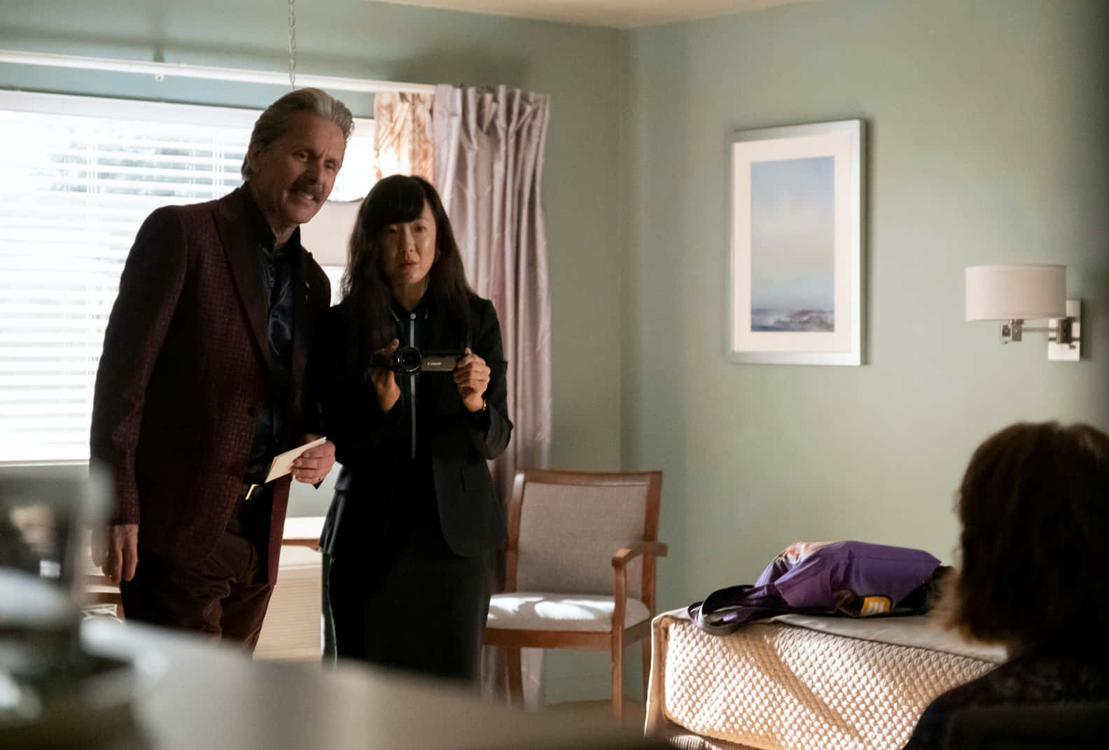 Gary Cole 桌布 壁紙 — 兩個人站在柔和燈光的房間裡，一個人拿著相機，另一個人則在旁邊微笑。