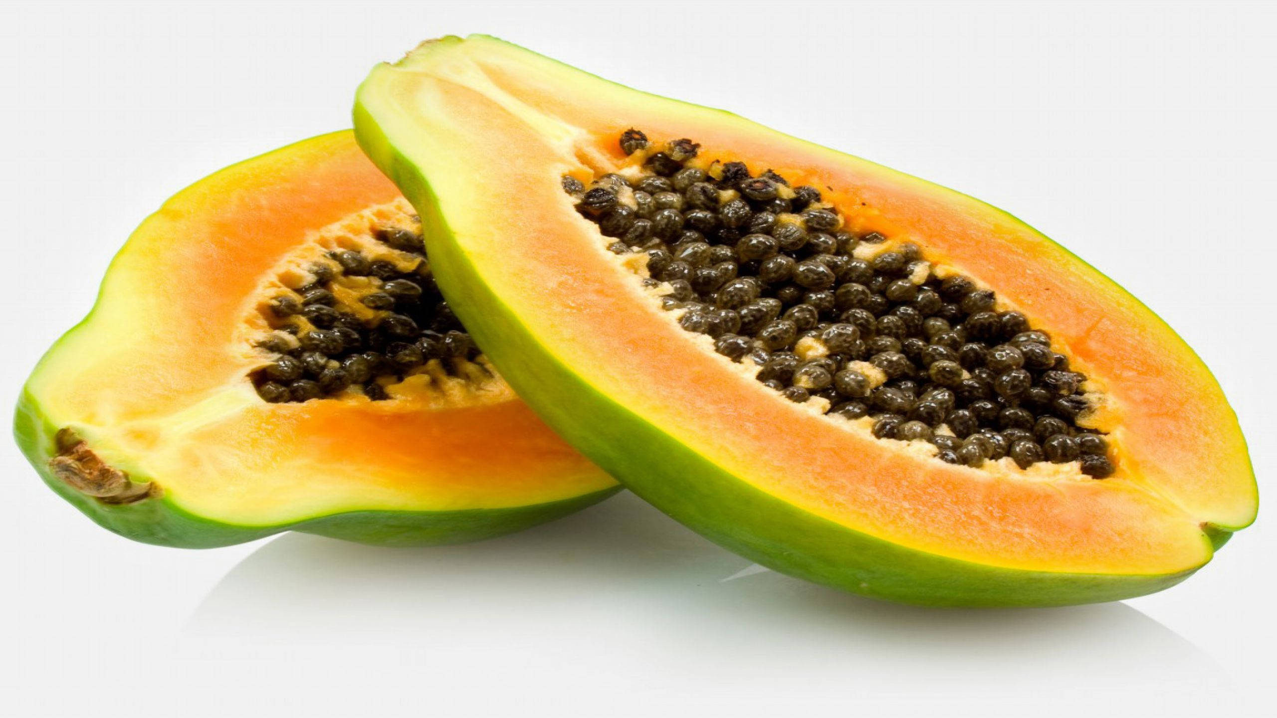 Fruit 桌布 壁紙 — 兩個充滿活力的半切木瓜，帶有多汁的橙色果肉和黑色種子，放在乾淨的白色表面上。