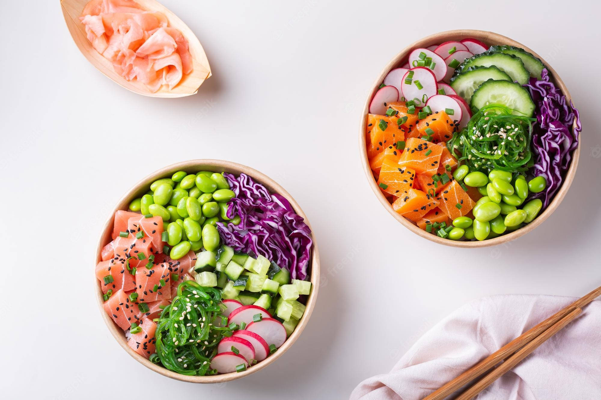 poke 桌布 壁紙 — 兩個充滿活力的木碗，裝滿色彩繽紛的壽司配料，如鮭魚、小黃瓜和毛豆，整齊地排列在乾淨的白色表面上。