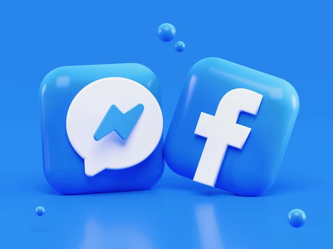 Facebook 桌布 壁紙 — 兩個光滑的藍色 3D 應用程式圖示（Facebook 和 Messenger）漂浮在純藍色背景上，並帶有漂浮的球體。