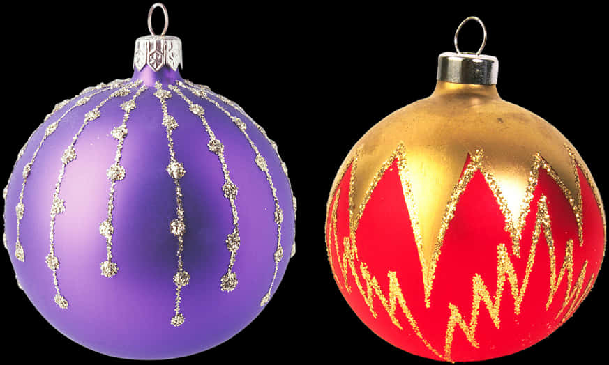 Christmas Decoration 桌布 壁紙 — 兩個光澤的聖誕裝飾品，一個紫色帶銀色閃粉線條，另一個金色帶紅色和金色鋸齒圖案，背景為黑色。