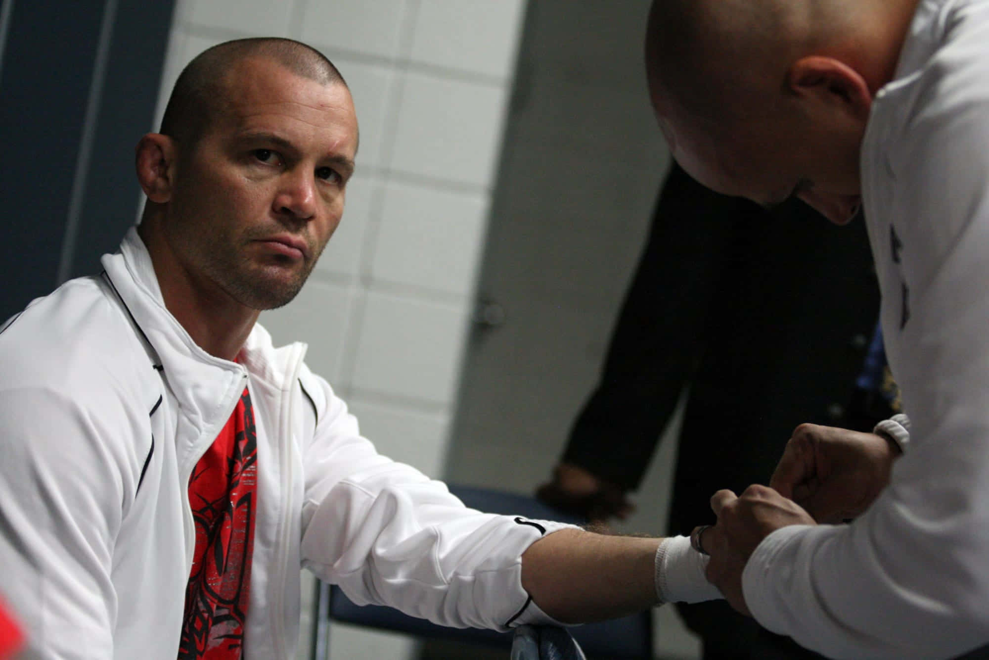 UFC 桌布 壁紙 — 兩個光頭男人穿著白色外套，在室內以專注的纏鬥姿勢激烈地鎖住手臂。