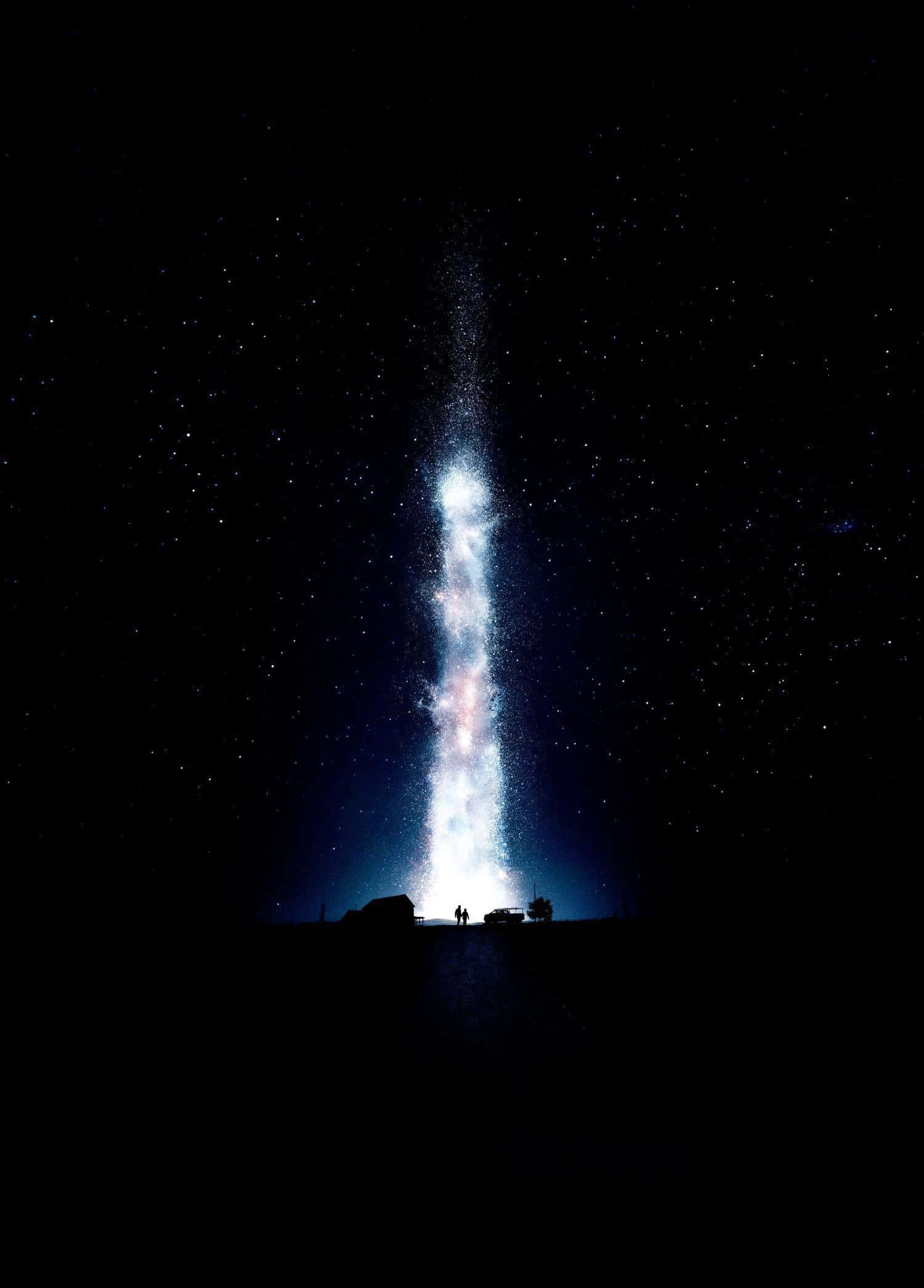iPhone Xs Oled 桌布 壁紙 — 兩個剪影人物站在一道穿透黑暗景觀上方星空夜空的耀眼宇宙柱前。