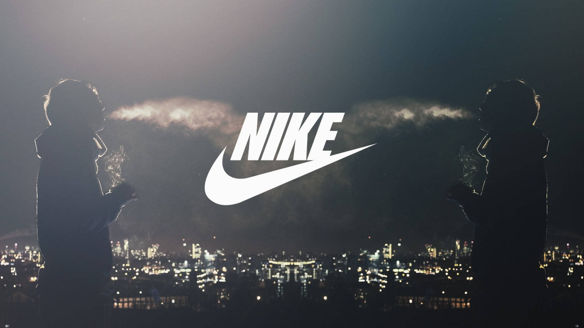 Nike iPhone 桌布 壁紙 — 兩個剪影人物站在夜晚的城市景觀之上，上方中央有一個發光的Nike標誌。