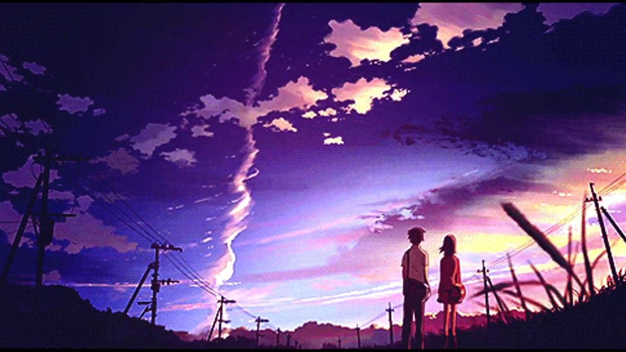 兩個人站在一起，觀看鄉村風景上空的彩色日落，有電線。 — 4K 壁紙