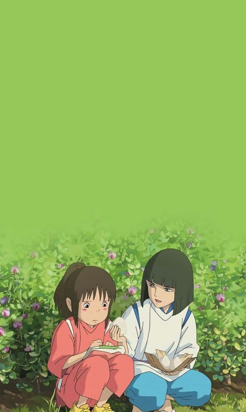 Haku Spirited Away Phone 桌布 壁紙 — 兩個動漫女孩並肩坐在一片綠草和紫色花朵的田野中，天空是純綠色。