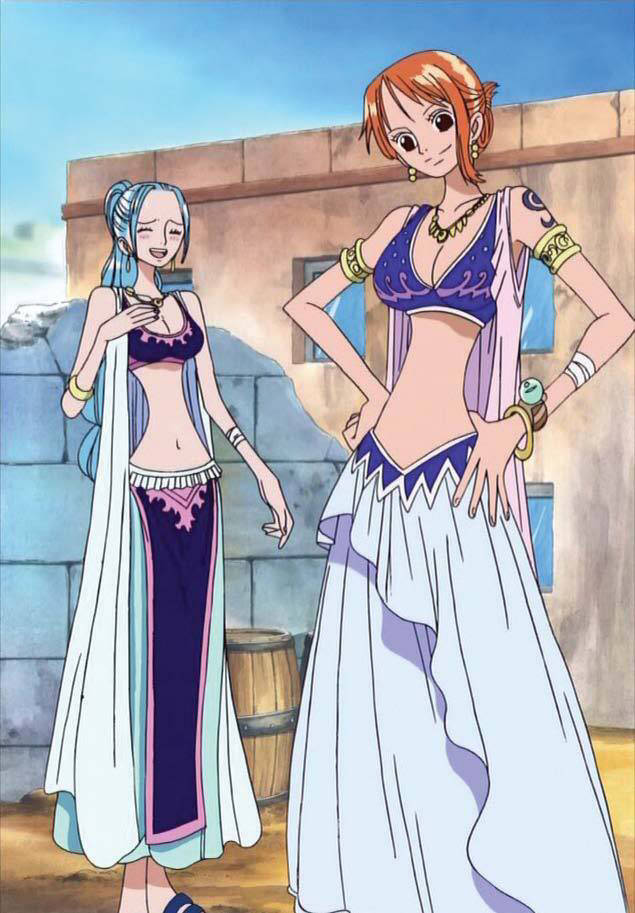 nefertari vivi 桌布 壁紙 — 兩個動漫女孩穿著華麗的藍白沙漠服裝，在晴朗的藍天下自信地站在石頭建築前。