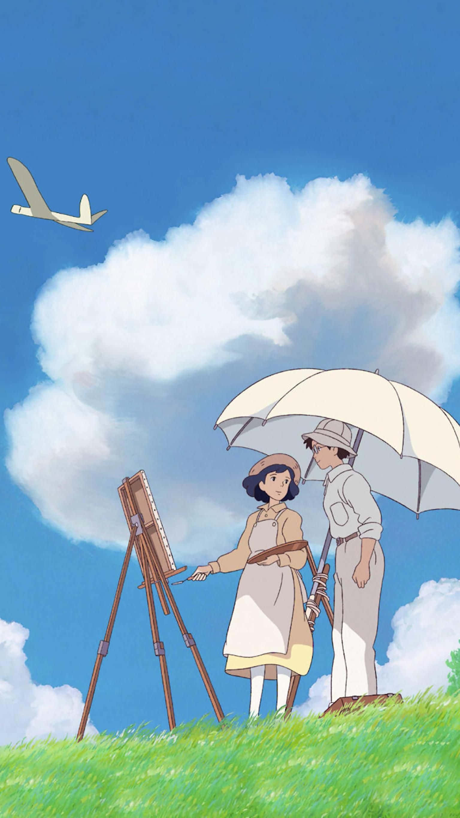 The Wind Rises 桌布 壁紙 — 兩個動漫角色在遮陽傘下畫風景，一架滑翔機飛過蓬鬆的雲朵，映襯著明亮的藍天。