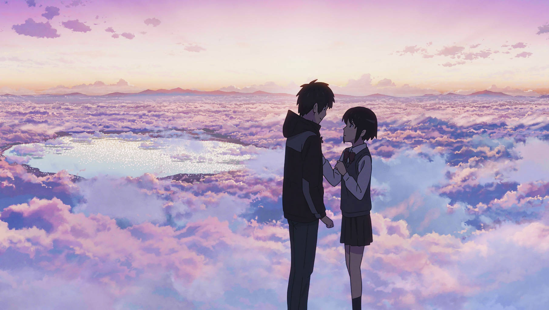 Makoto Shinkai 桌布 壁紙 — 兩個動漫青少年在日落時分，在粉紫色雲海之上牽手，俯瞰遠處的湖泊。