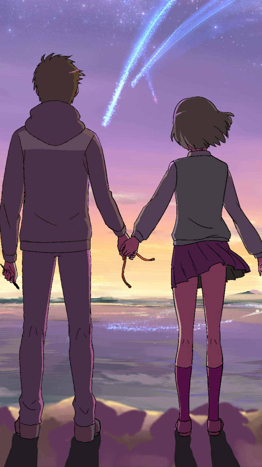 kimi no na wa phone 桌布 壁紙 — 兩個動漫青少年在海灘上牽手，看著鮮藍色的流星劃過暮色天空。