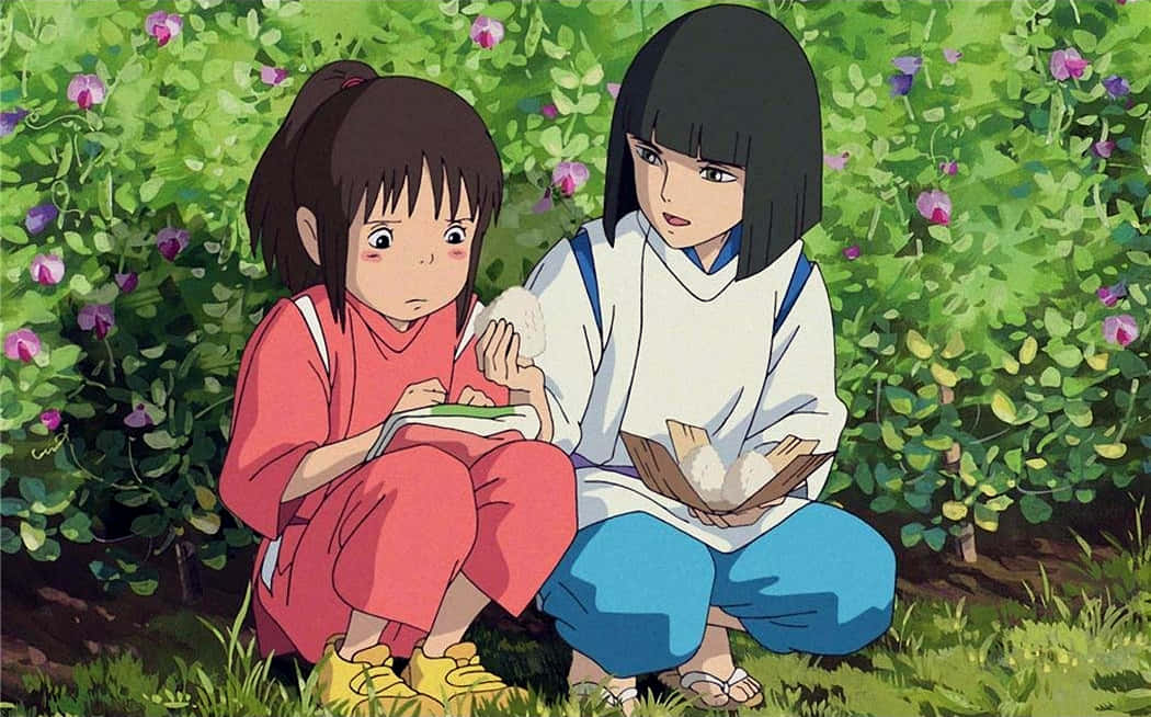 吉卜力 桌布 壁紙 — 兩個動畫女孩坐在陽光普照的花園裡，吃著飯糰，周圍是綠色樹葉和紫色花朵。