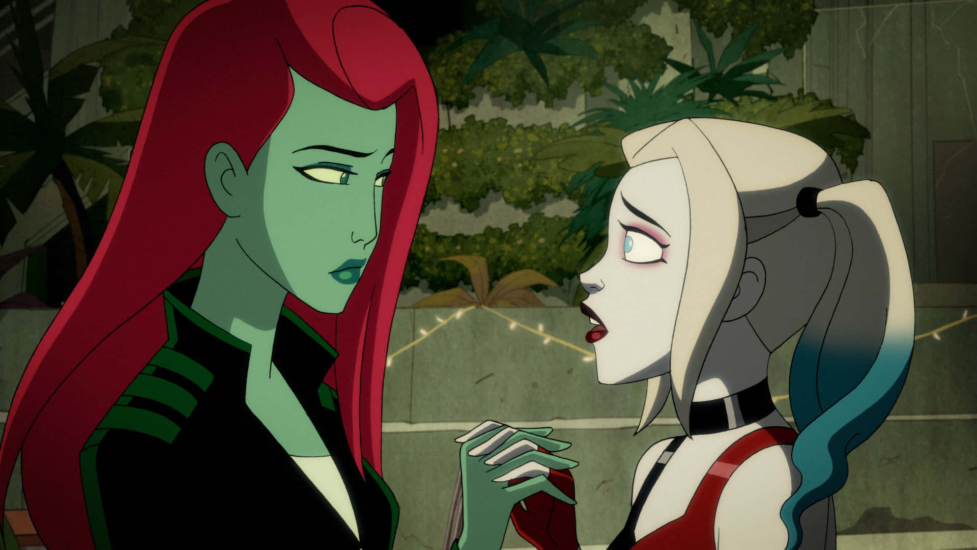 Harley Quinn And Poison Ivy 桌布 壁紙 — 兩個動畫女性角色，分別有明顯的紅髮和金髮，在一個光線昏暗的戶外環境中面對面，周圍有燈串和樹葉。