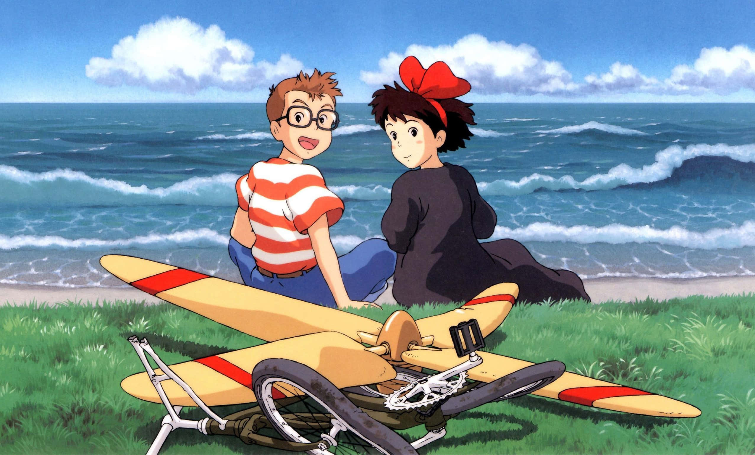 kiki's delivery service 桌布 壁紙 — 兩個動畫小孩坐在一個有草的海灘上，旁邊是一架帶有紅色條紋的黃色滑翔機，背後有海浪拍打。