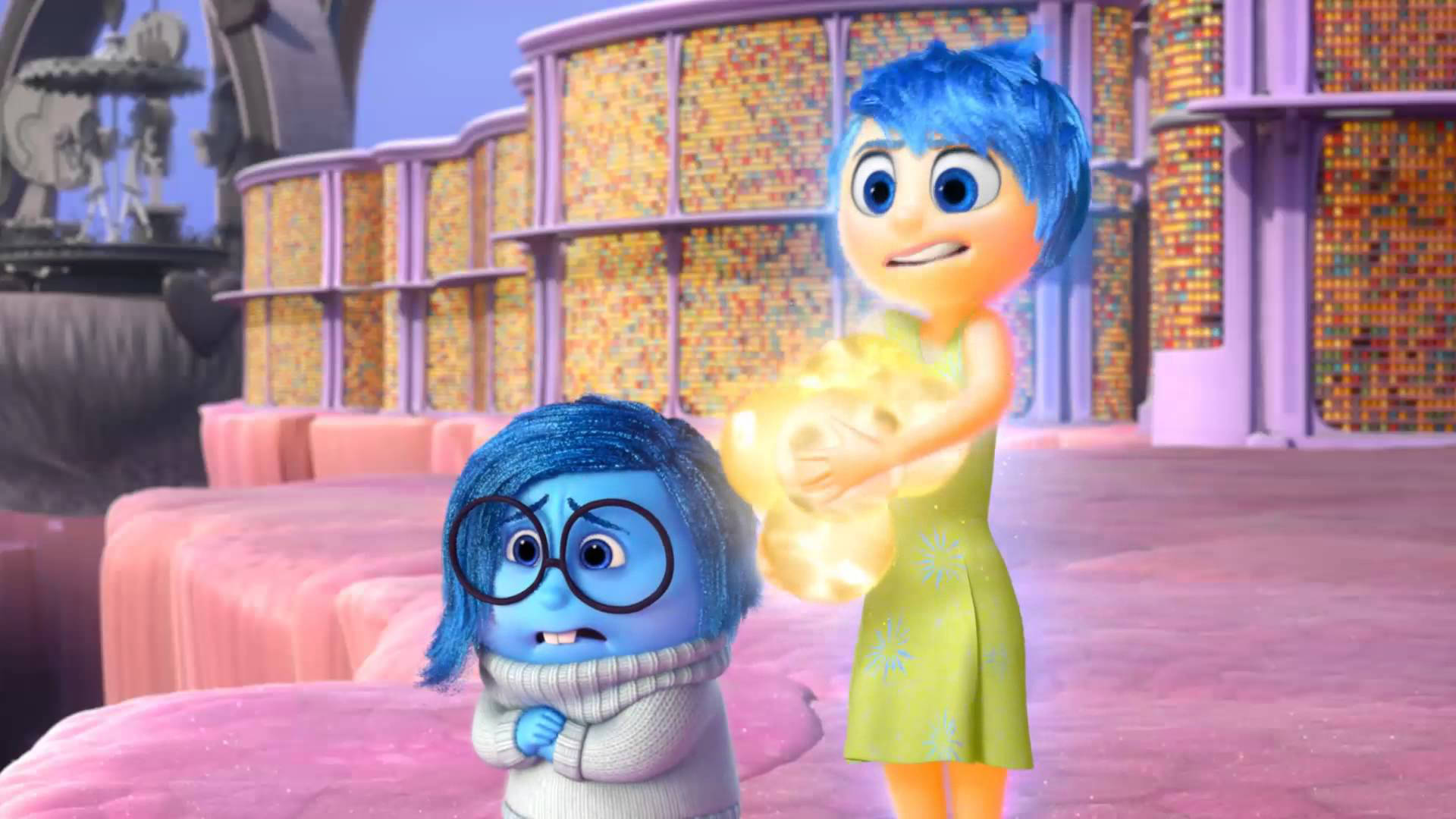 Joy Inside Out 桌布 壁紙 — 兩個動畫情感角色，一個藍色戴眼鏡的角色看起來很擔心，而另一個藍色角色在色彩繽紛的超現實場景中拿著發光的黃色記憶球。