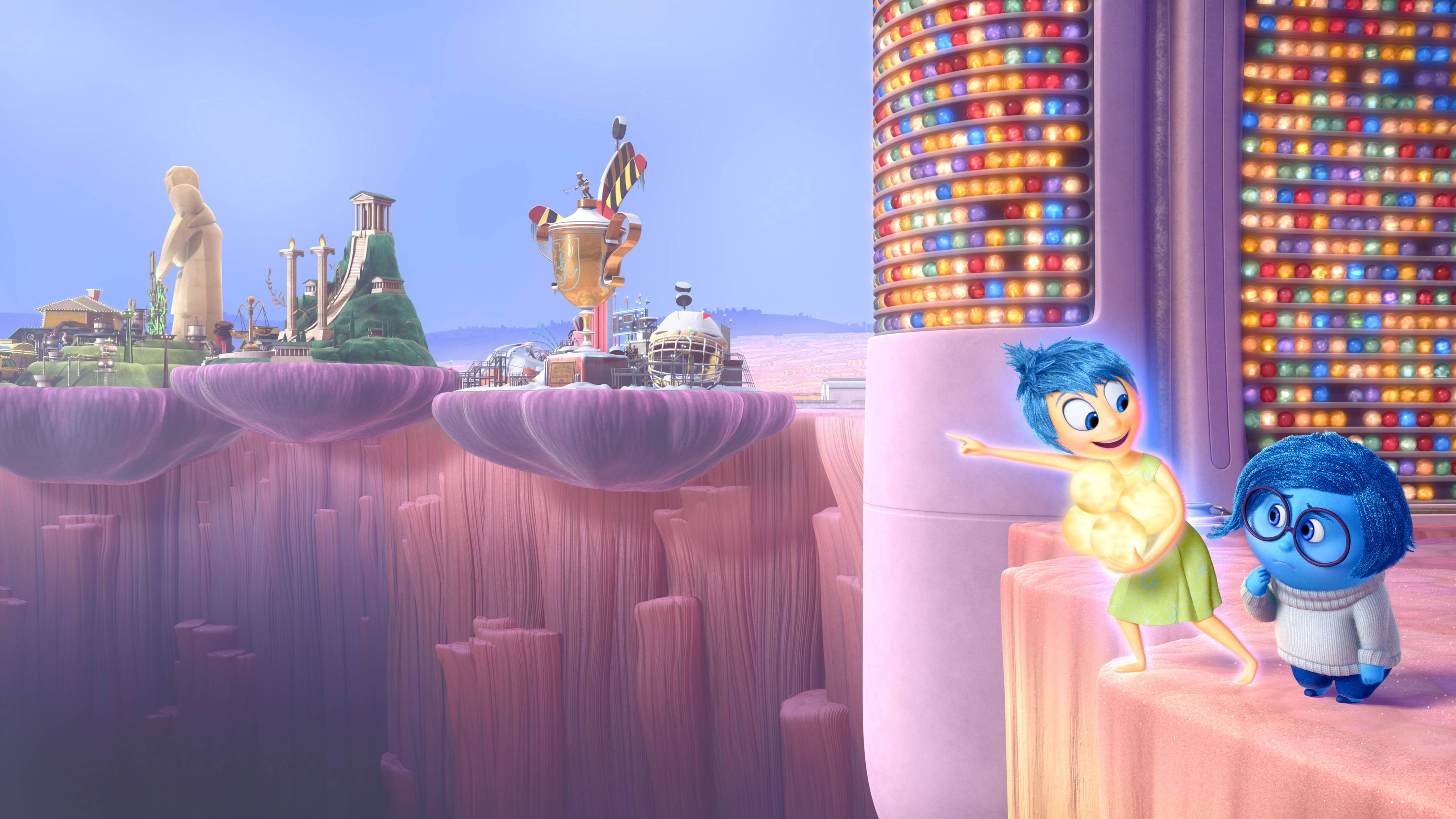 Joy Inside Out 桌布 壁紙 — 兩個動畫情感角色站在一個漂浮平台上，俯瞰著一個超現實、色彩繽紛的記憶景觀，其中有發光的塔樓和奇特的結構。