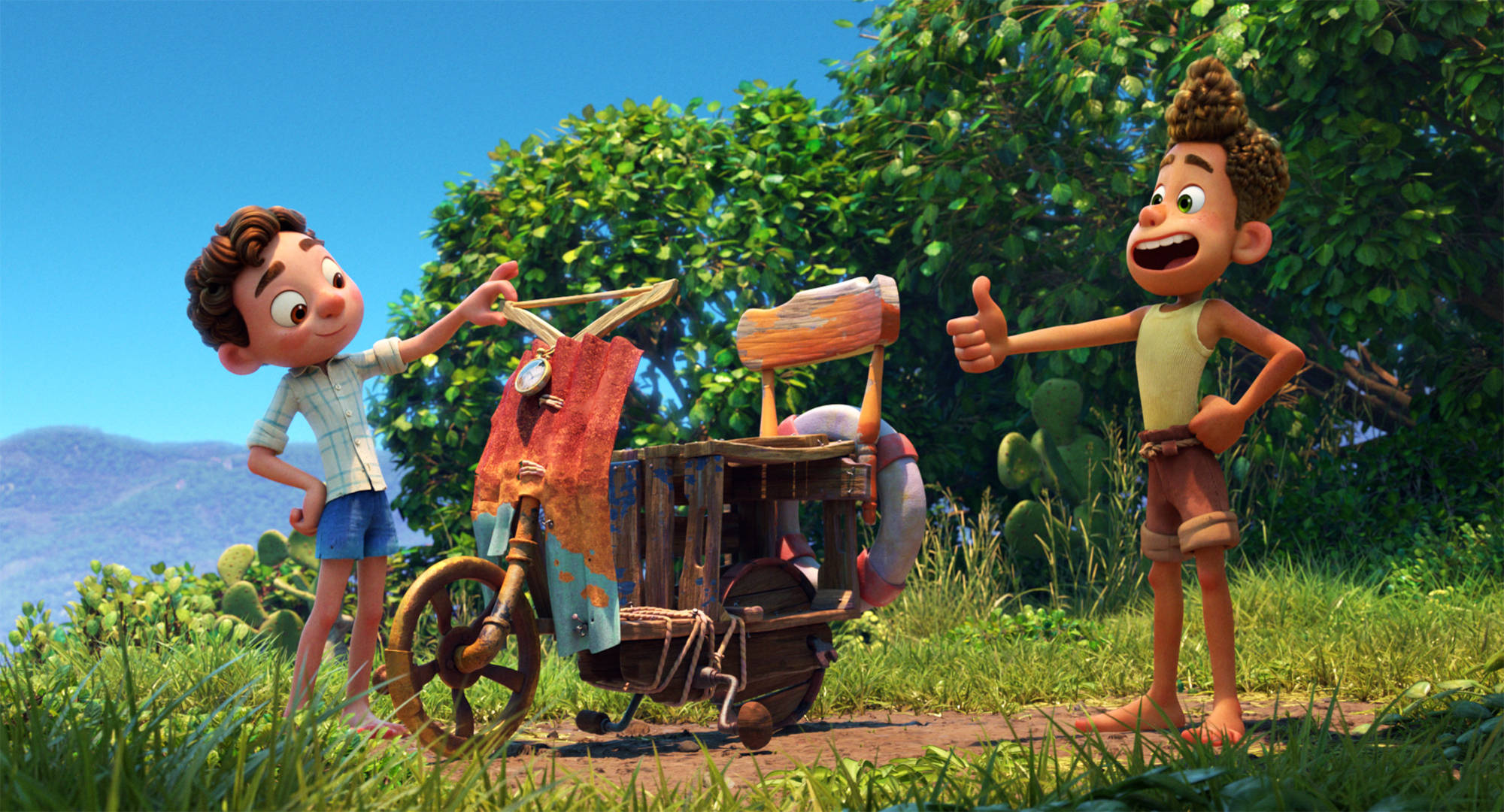Pixar Luca 桌布 壁紙 — 兩個動畫男孩愉快地站在一個質樸的三輪車旁邊，在一個陽光明媚、有仙人掌和樹木的草地上。