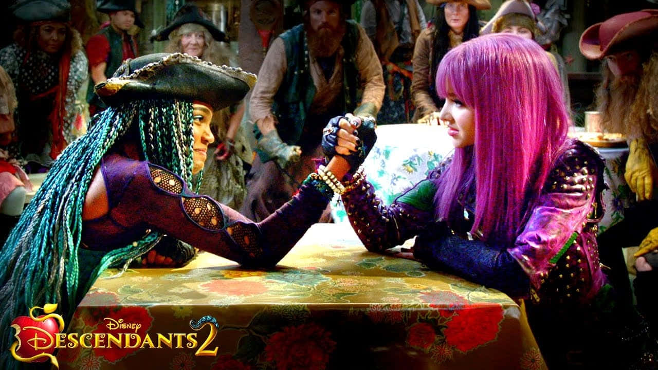 Descendants 桌布 壁紙 — 兩個動畫角色，擁有鮮豔的紫色和藍綠色頭髮，在一張花卉桌子旁進行緊張的掰手腕比賽，周圍有圍觀者。