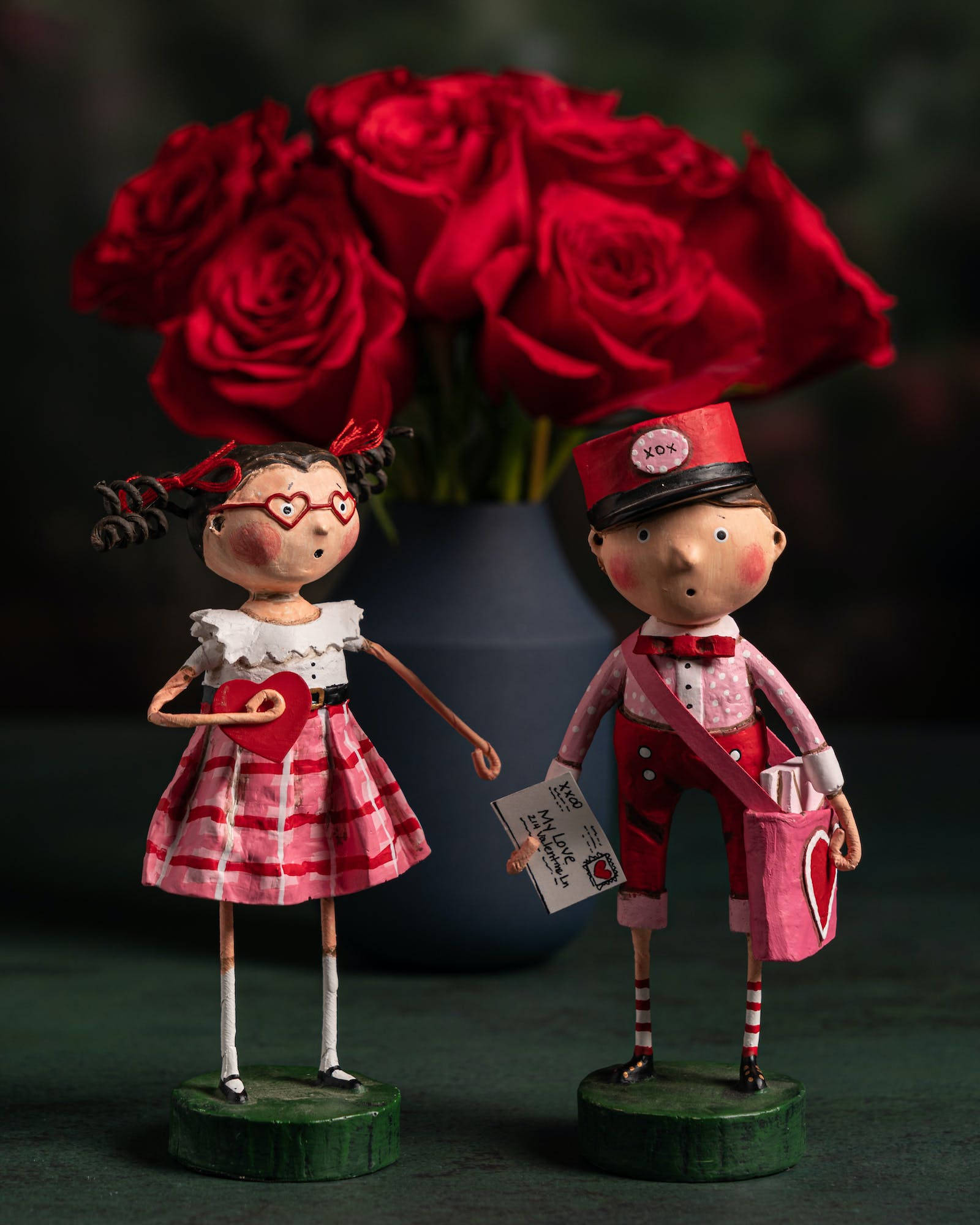 Dolls 桌布 壁紙 — 兩個古怪的手工製愛情主題公仔站在茂盛的紅玫瑰花束前。