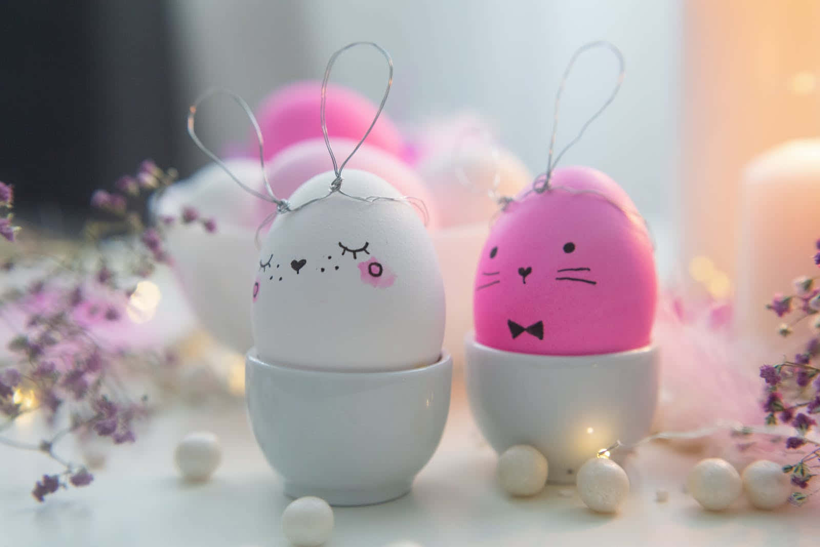 Eggs 桌布 壁紙 — 兩個可愛兔臉蛋放在白色杯子中，周圍環繞著粉紅色花朵和仙女燈。