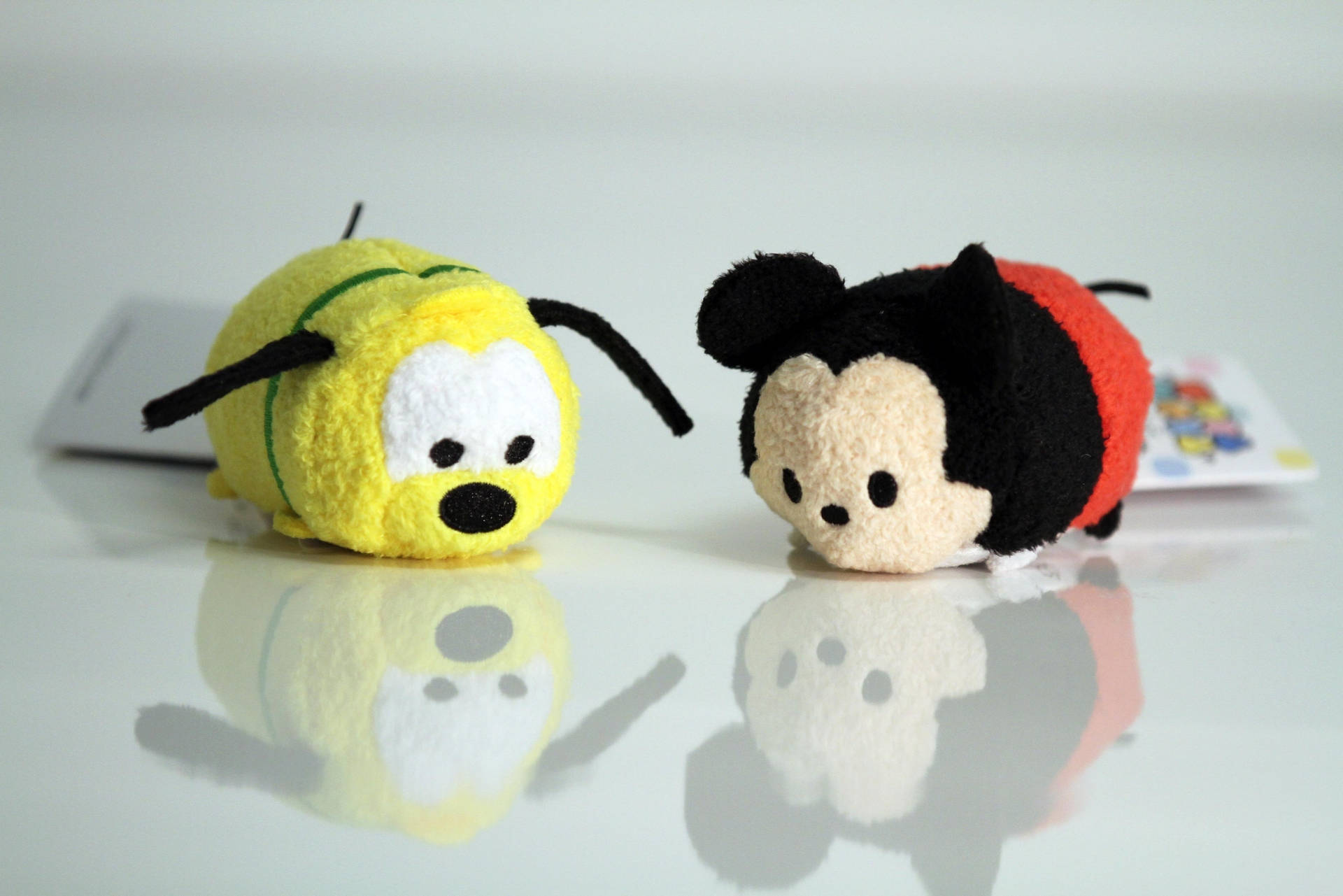 兩個迪士尼 Tsum Tsum 毛絨玩具米奇和布魯托在反光的白色表面上。 — Tsum tsum 壁紙
