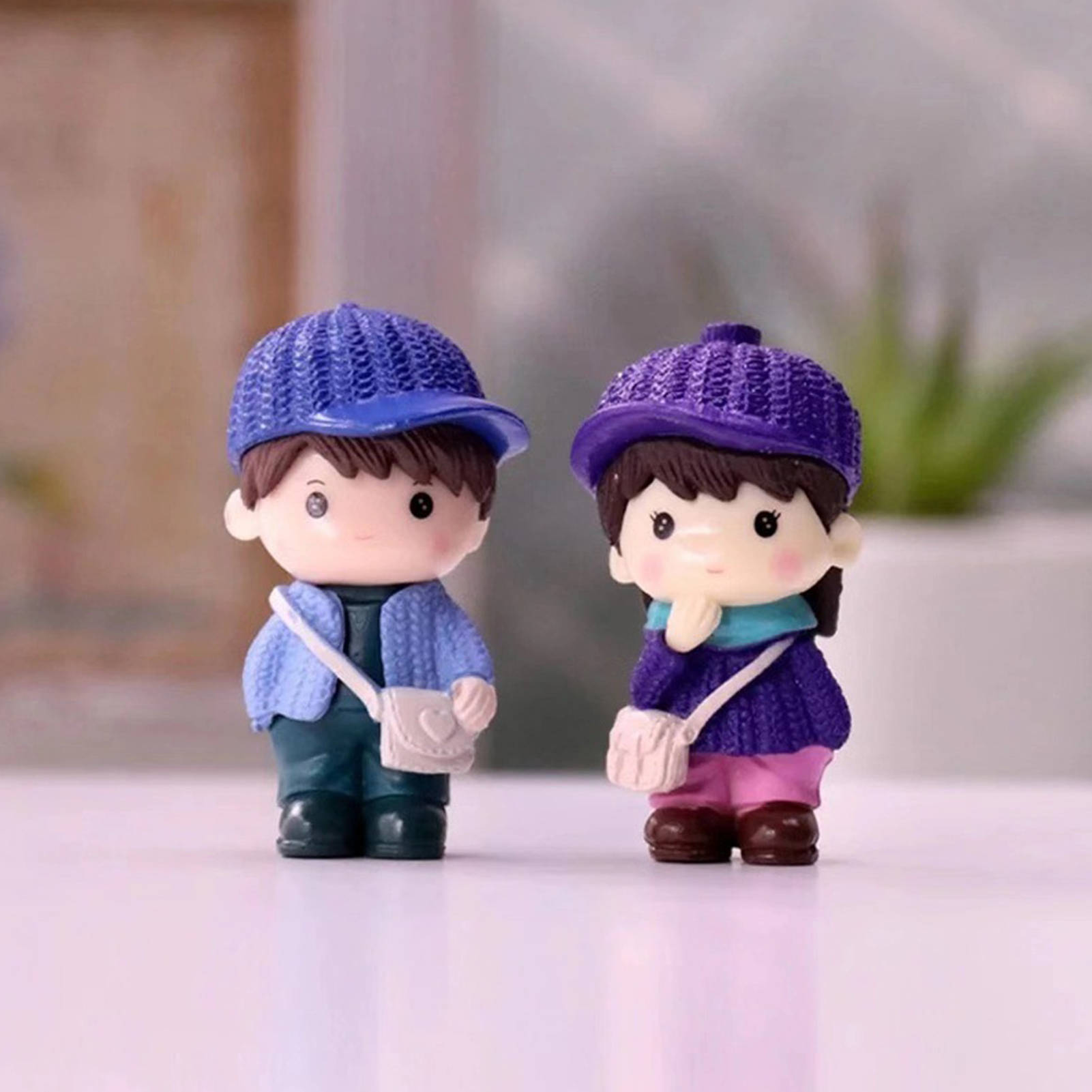 cute doll couple 桌布 壁紙 — 兩個可愛的Q版公仔戴著針織帽和斜背包，並排站在白色表面上。