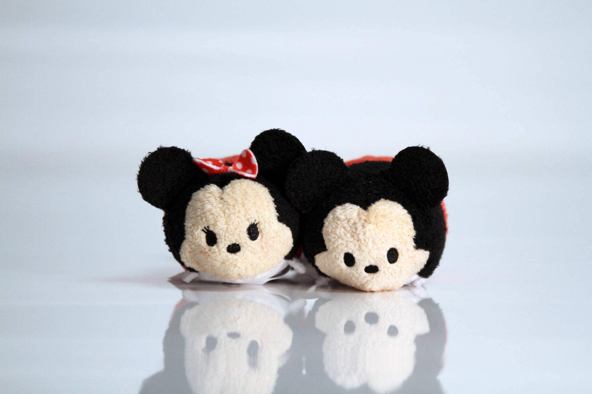 兩個米奇和米妮Tsum Tsum毛絨玩偶躺在反光的白色表面上。 — Tsum tsum 壁紙