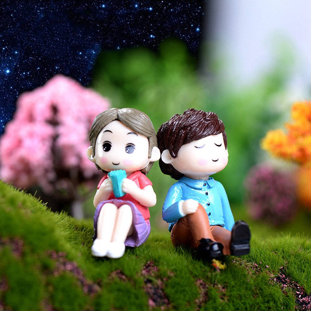 cute doll couple 桌布 壁紙 — 兩個可愛的公仔坐在長滿苔蘚的草地上，背景是繁星點點的夜空和模糊的彩色樹木。