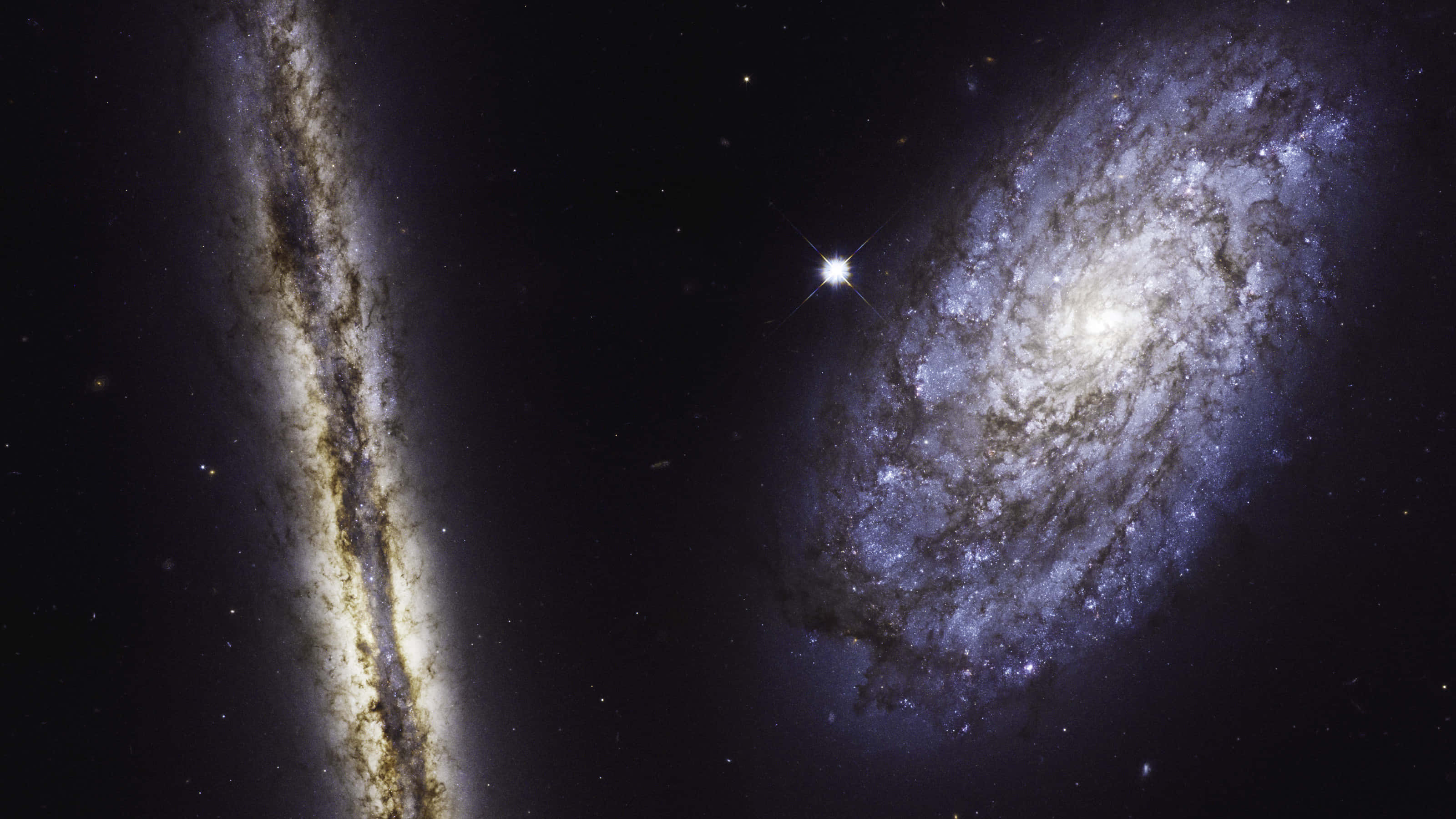 Nasa Galaxy 桌布 壁紙 — 兩個壯麗的螺旋星系在深空中旋轉，一顆明亮的恆星在它們之間閃耀。