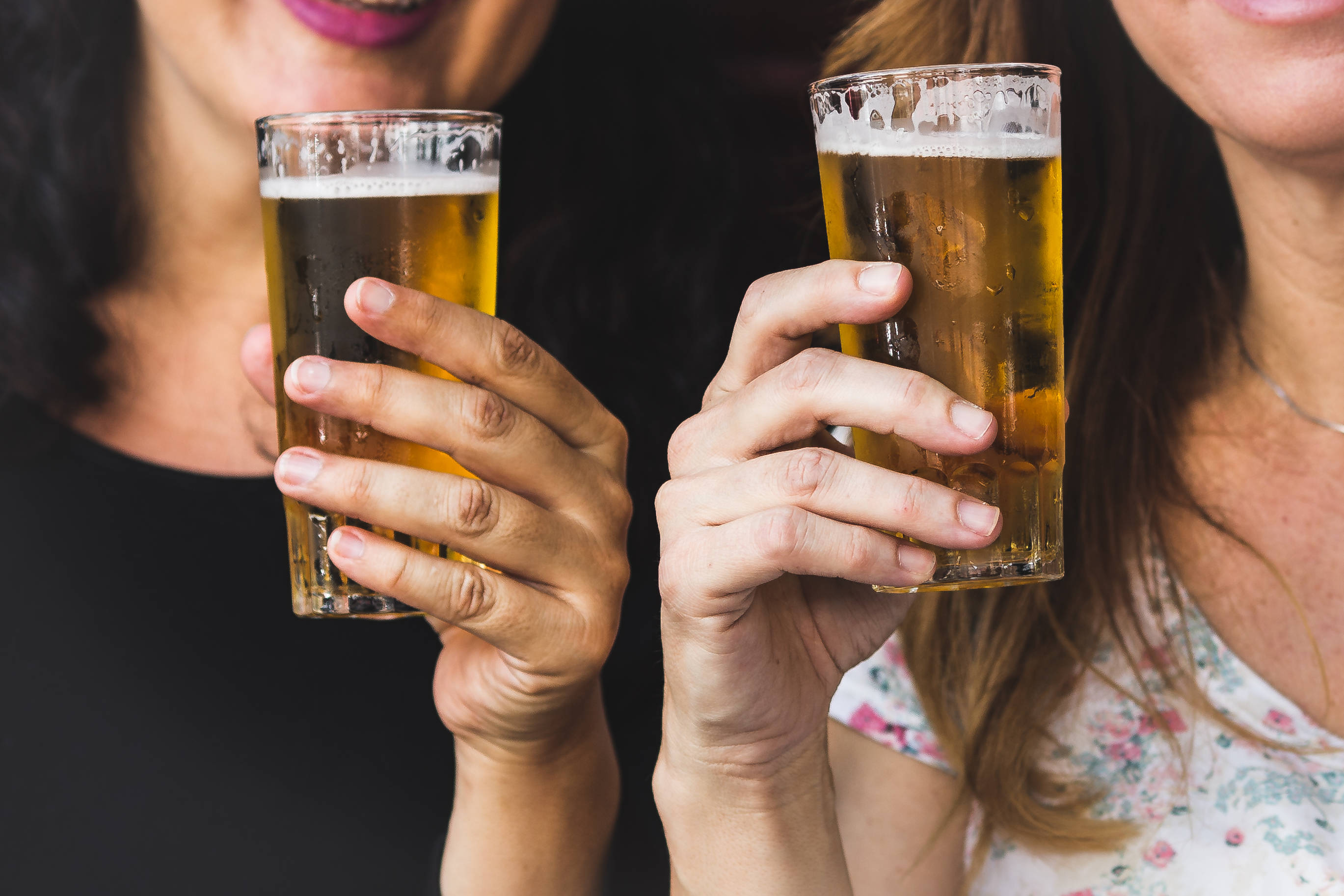 Beer 桌布 壁紙 — 兩個女人微笑著碰杯冰啤酒的特寫鏡頭。