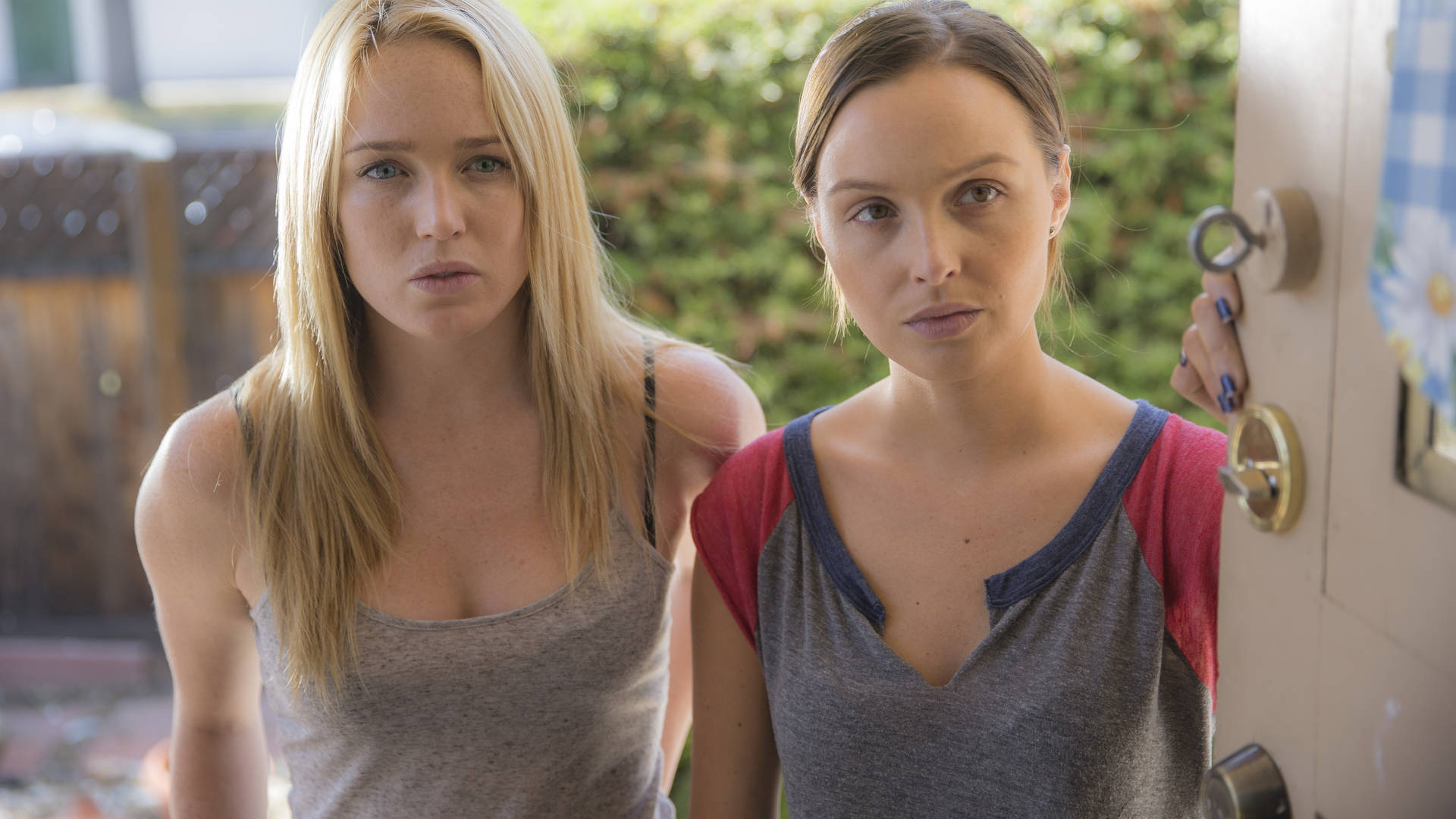 兩個女人站在門口，其中一個拿著鑰匙，表情嚴肅。 — Caity Lotz 動圖 壁紙
