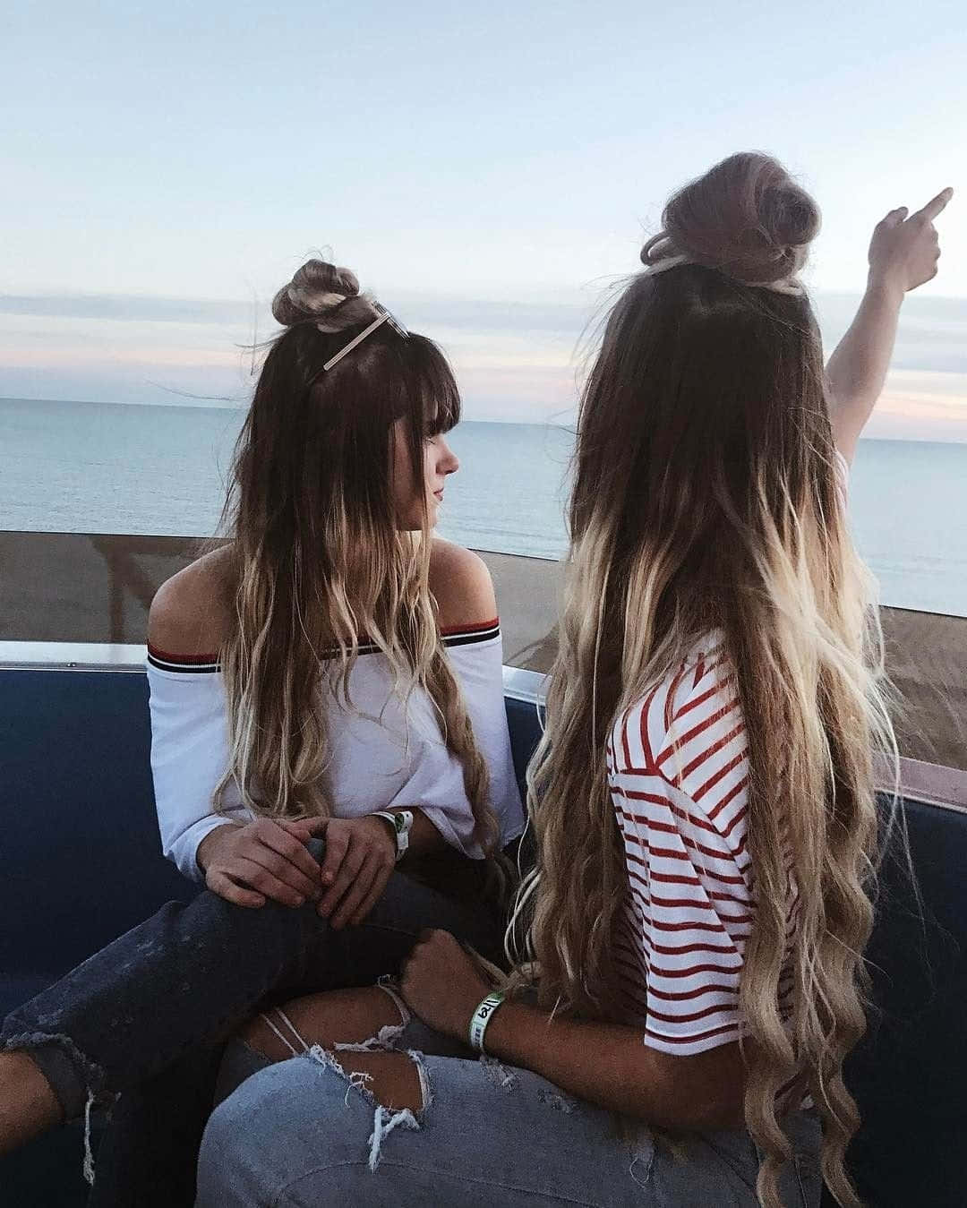 兩個女孩坐在船上，頭髮都綁成髻 壁紙