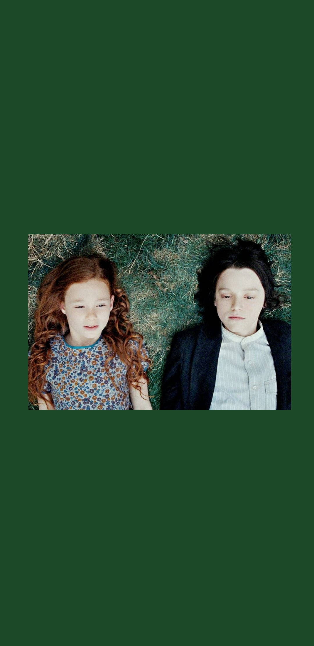 snape 桌布 壁紙 — 兩個孩子並排躺在草地上，深綠色的天空下，靜靜地向上凝視。