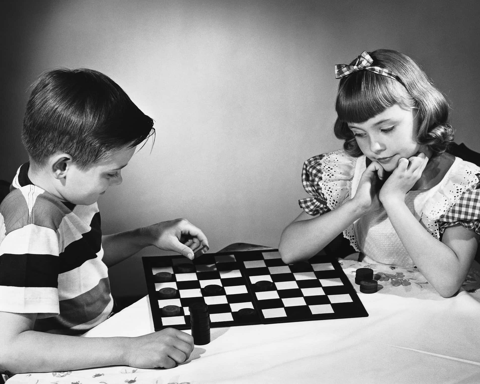 1950s 桌布 壁紙 — 兩個孩子在復古黑白照片中專注於跳棋遊戲。