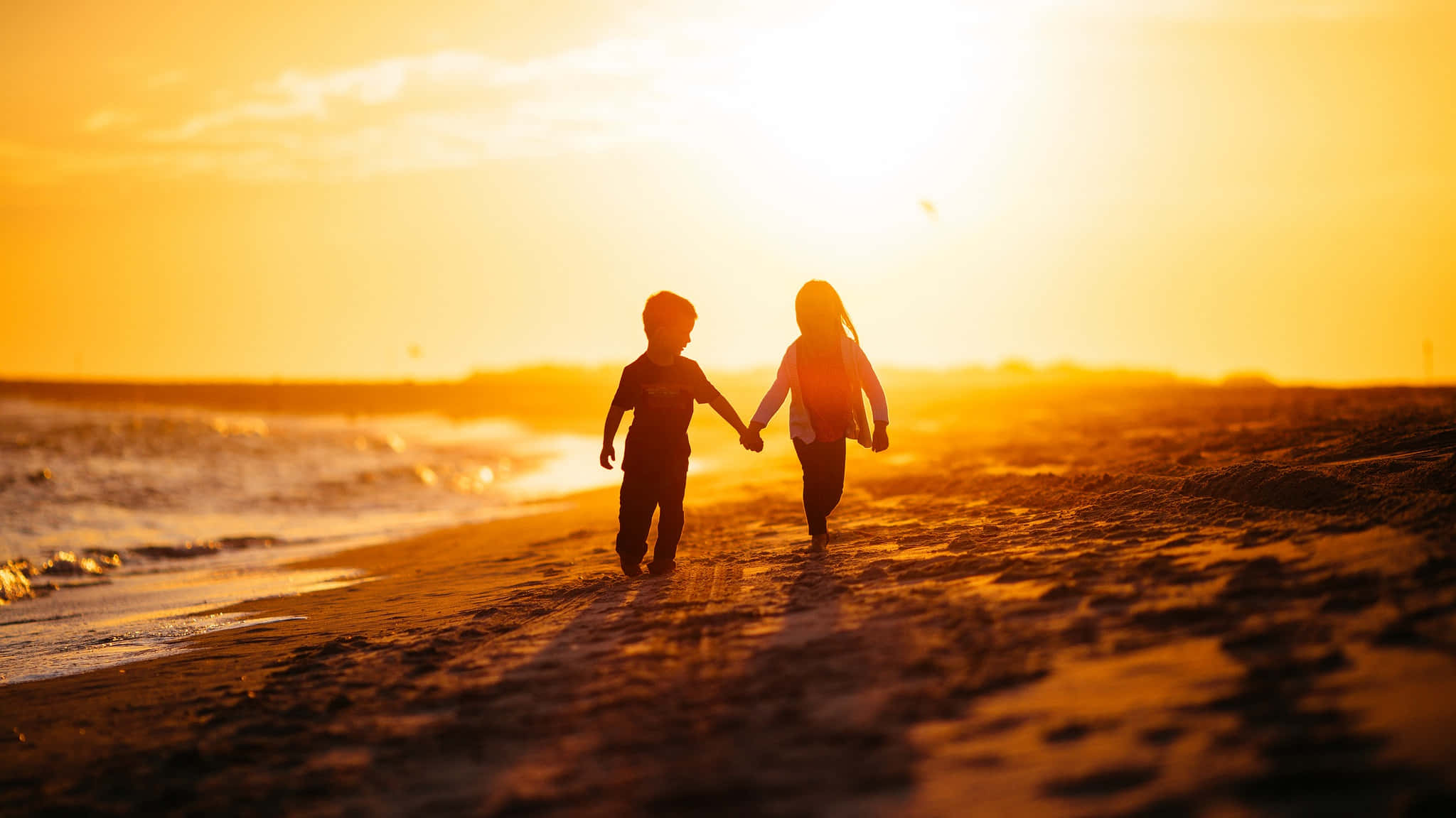 Beach Love 桌布 壁紙 — 兩個孩子手牽手沿著沙灘奔向閃耀的日落。