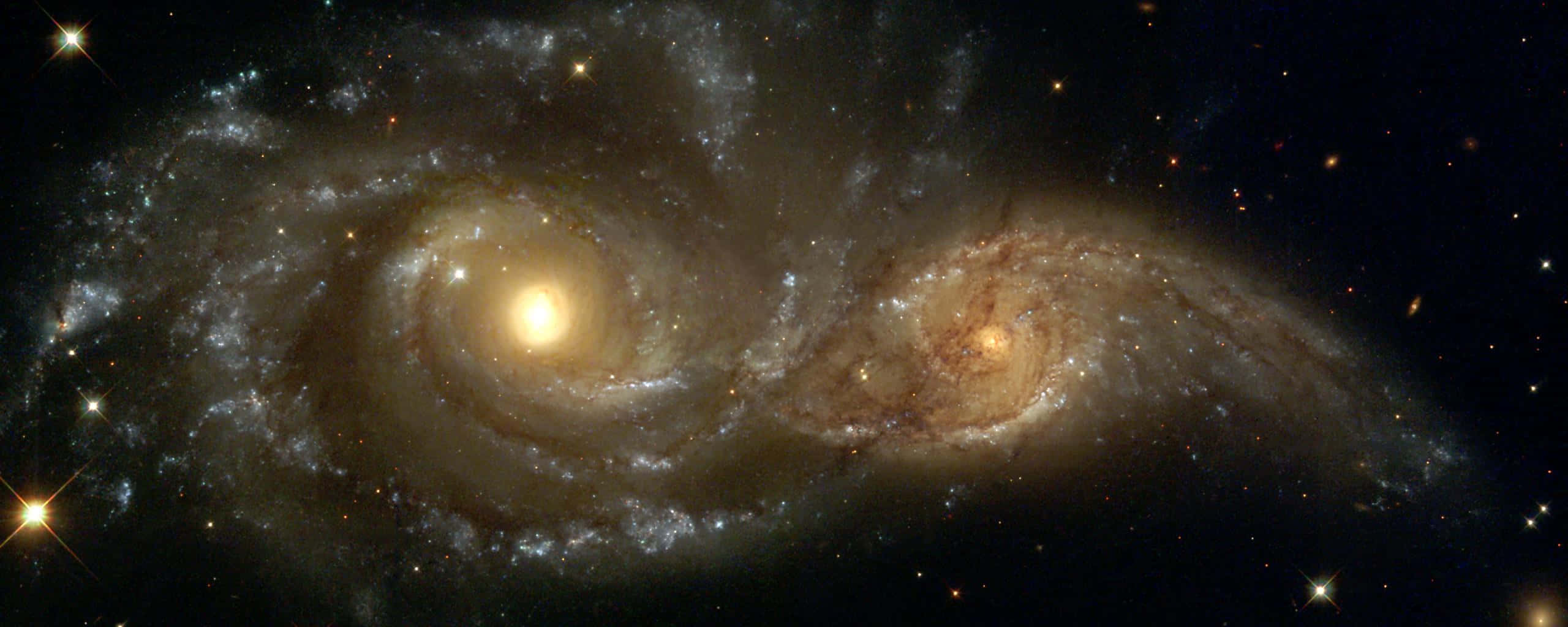 銀河 桌布 壁紙 — 兩個宏偉的螺旋星系在佈滿星空的黑色虛空中進行宇宙之舞並碰撞。