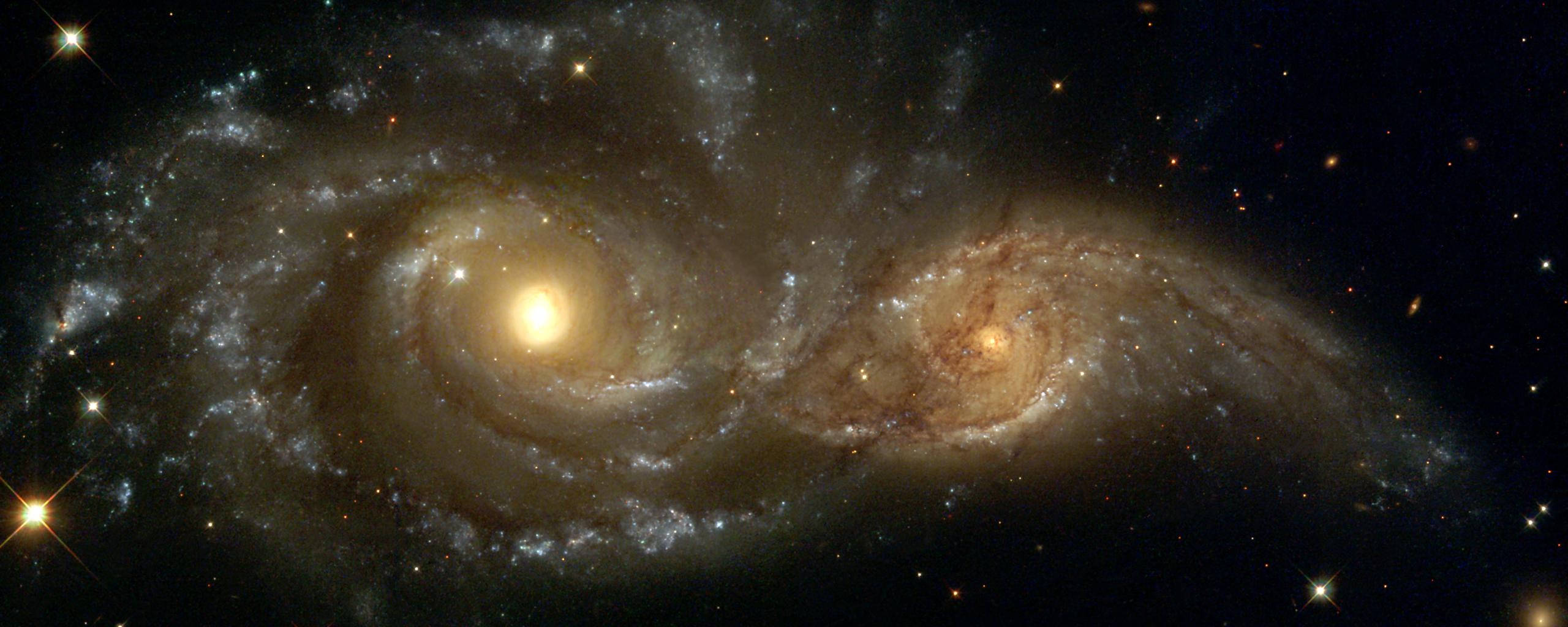 Pretty Galaxy 桌布 壁紙 — 兩個宏偉的螺旋星系在黑暗虛空中，以恆星、塵埃和發光星雲的宇宙之舞相撞。
