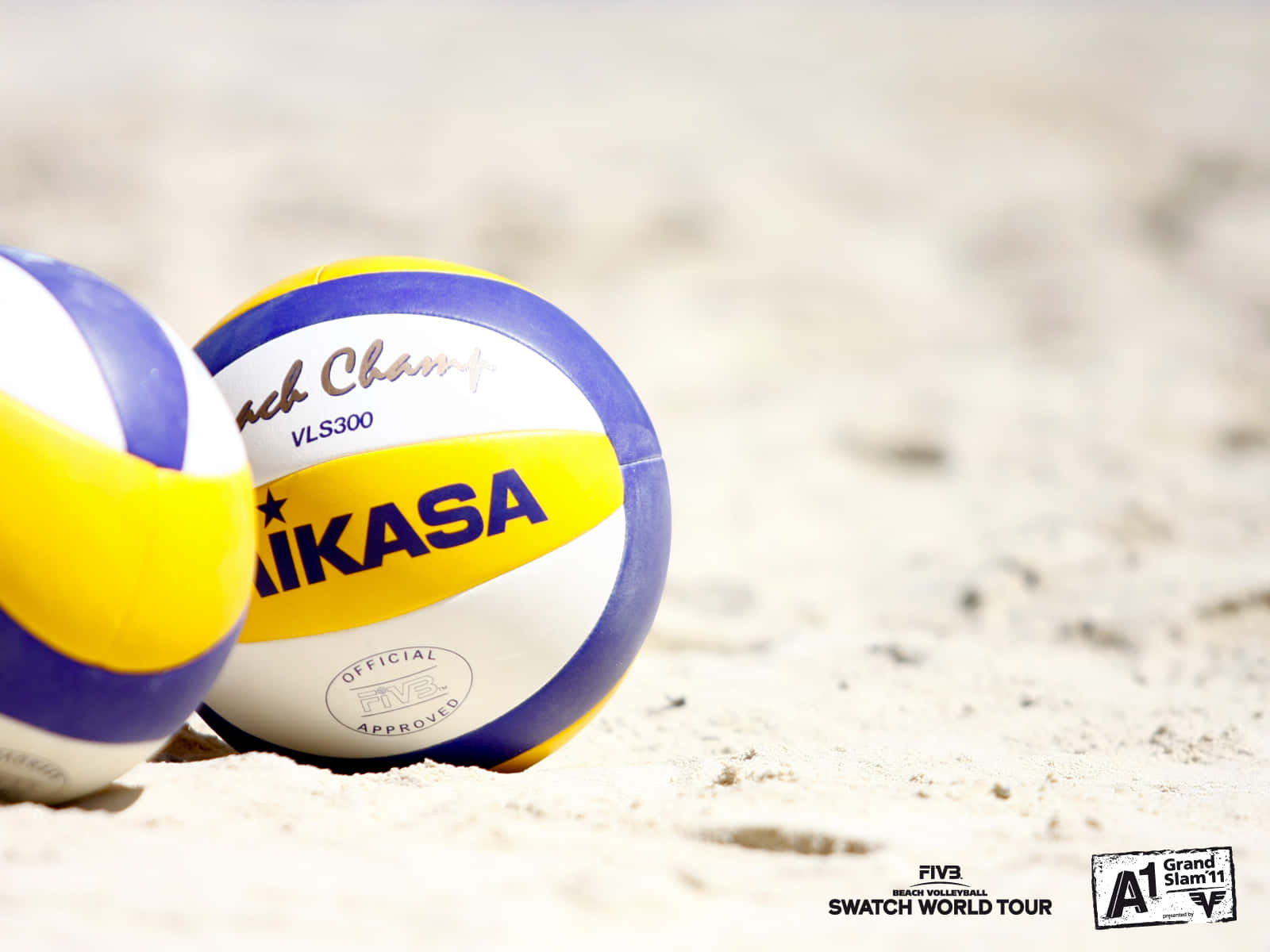Volleyball Ball 桌布 壁紙 — 兩個官方 Mikasa 沙灘排球放在陽光照耀的沙上，景深較淺。