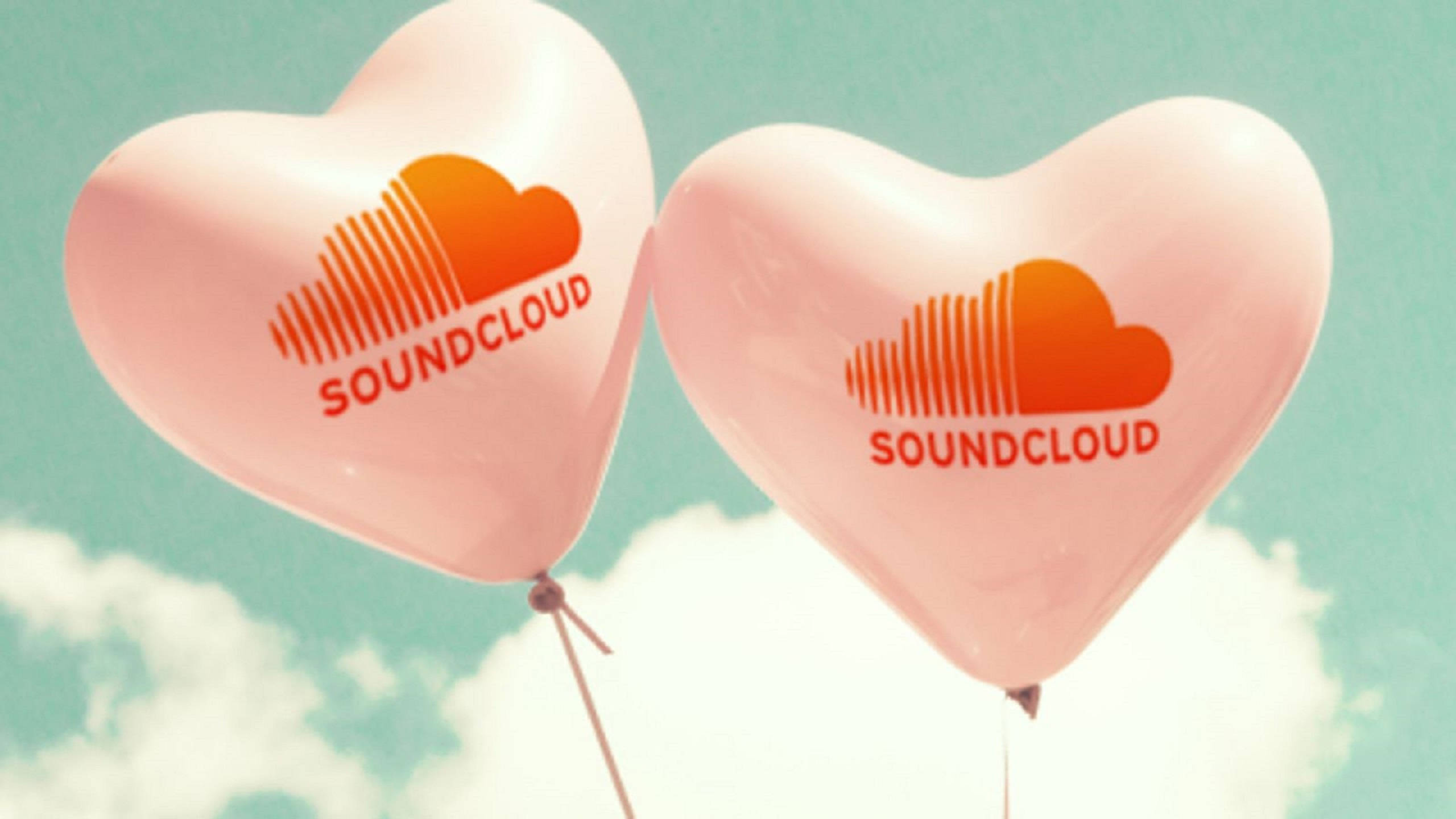 Soundcloud 桌布 壁紙 — 兩個帶有 SoundCloud 標誌的粉紅色心形氣球，在柔和的藍綠色天空和 fluffy 白色雲朵中輕輕飄浮。