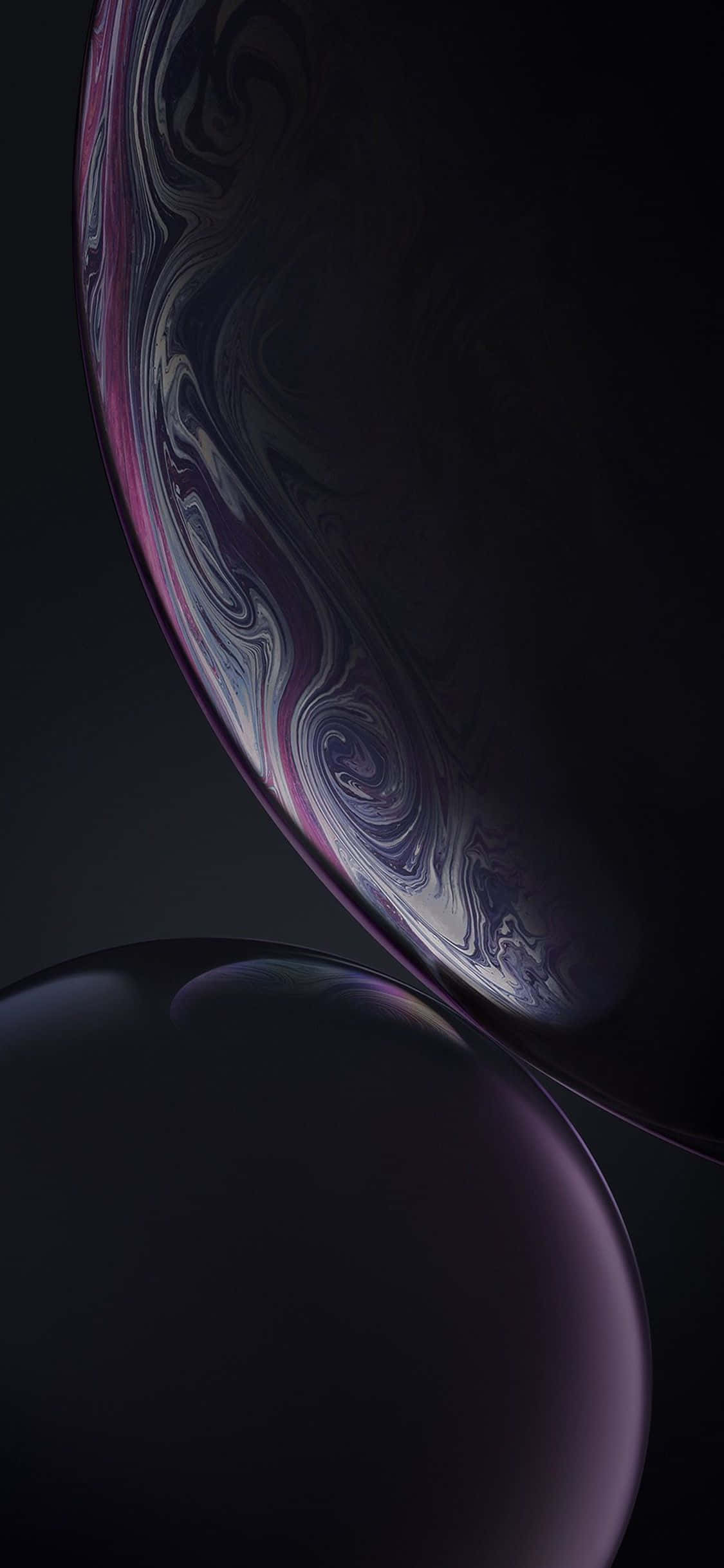 apple iPhone default 桌布 壁紙 — 兩個帶有紫色、銀色和黑色漩渦圖案的光澤球體漂浮在深色背景上。