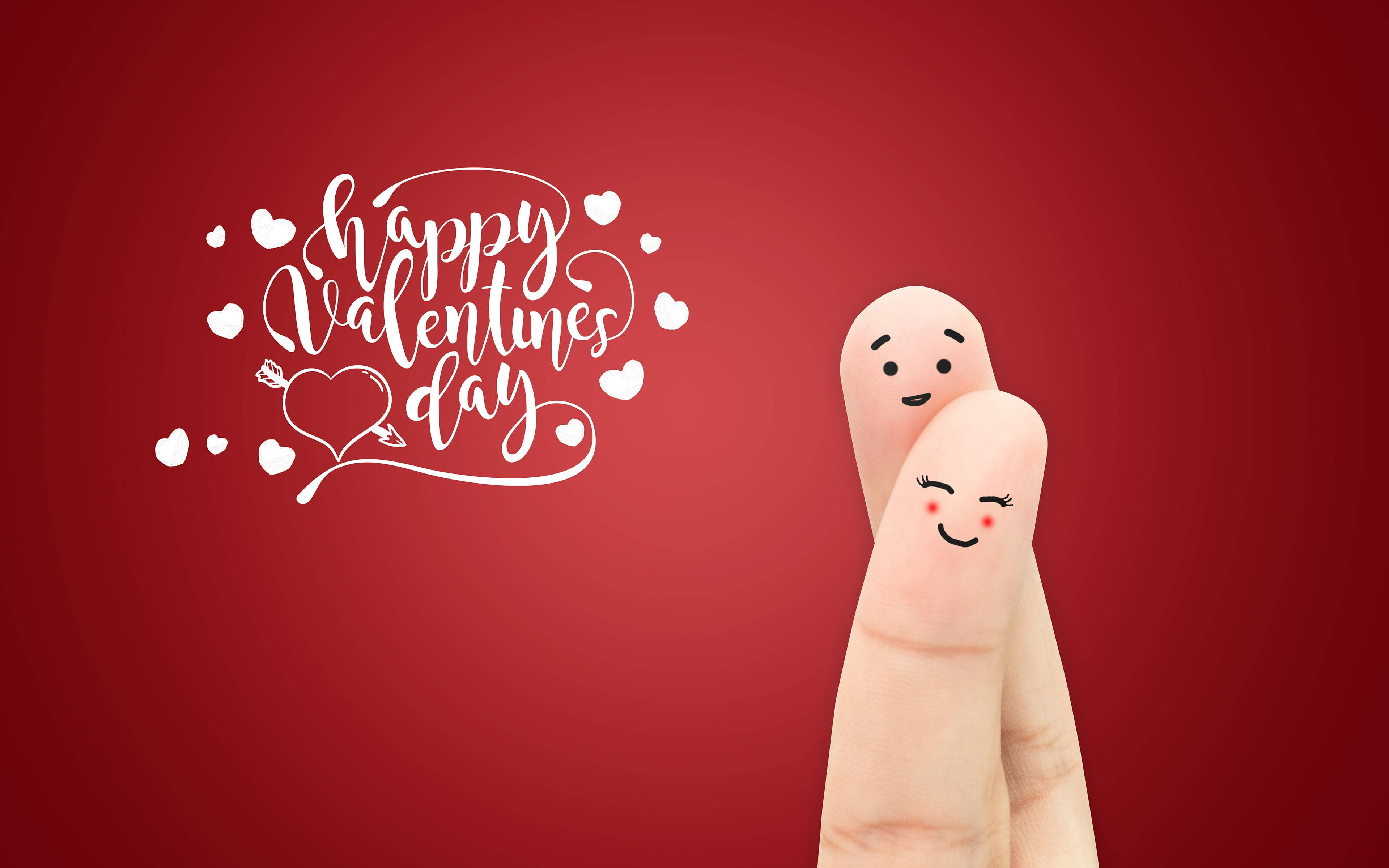 Happy Valentines Day 桌布 壁紙 — 兩個帶有繪製笑臉的手指角色在紅色背景上擁抱，並帶有白色 'Happy Valentine's Day' 書法和心形圖案。