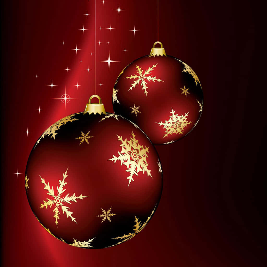 iPad Christmas 桌布 壁紙 — 兩個帶有金色雪花圖案的亮面紅色聖誕裝飾品掛在深紅色星空背景上。