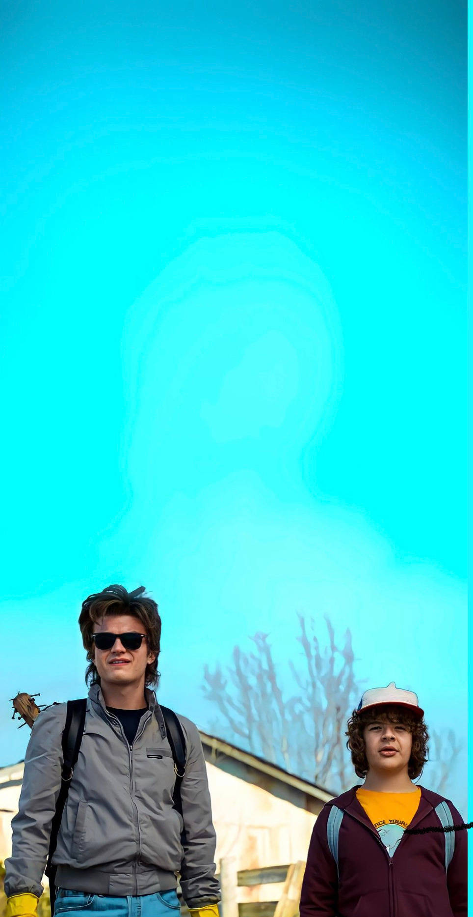 Dustin Stranger Things 桌布 壁紙 — 兩個年輕男子站在明亮的青色天空下，身後有一個幽靈般的半透明身影若隱若現。